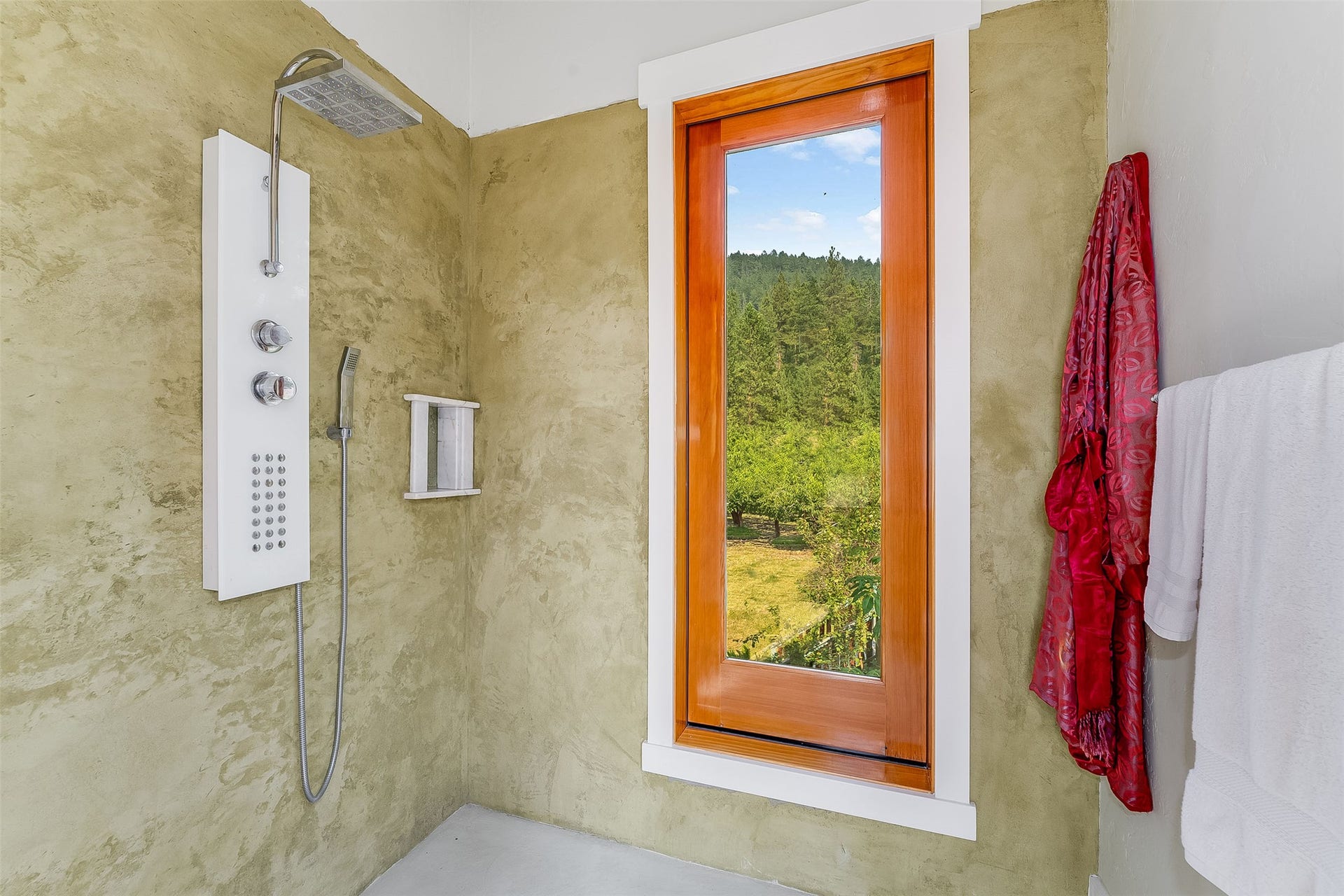 21848 Mt Highway 35, Bigfork, MT 59911 Spacious shower with a multi-function shower panel, integrated handheld shower, and a large window featuring a natural landscape