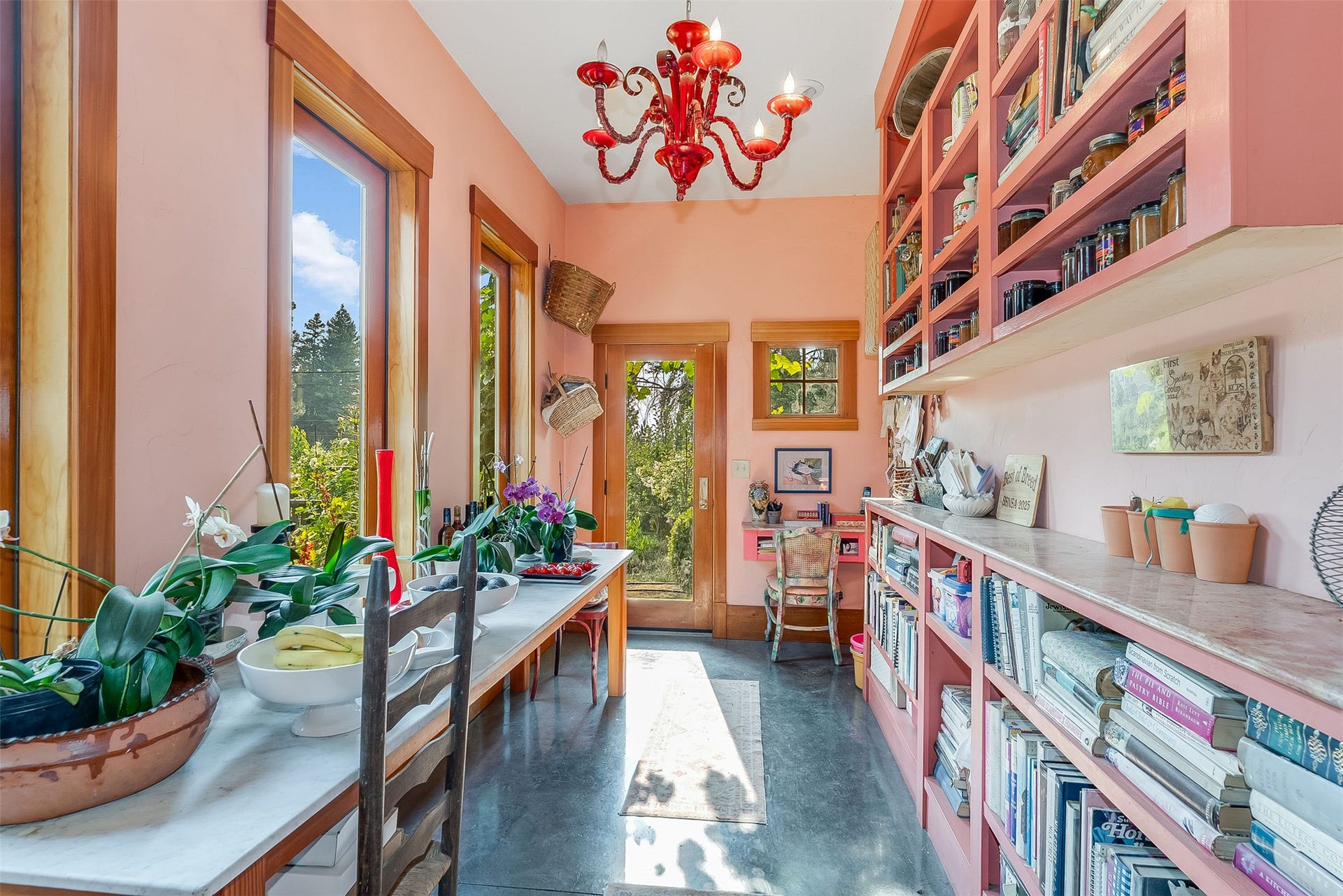 21848 Mt Highway 35, Bigfork, MT 59911 Entry to receiving area and sunroom/hallway to kitchen. Floor to ceiling shelving for display of fruit preserves and glassware.