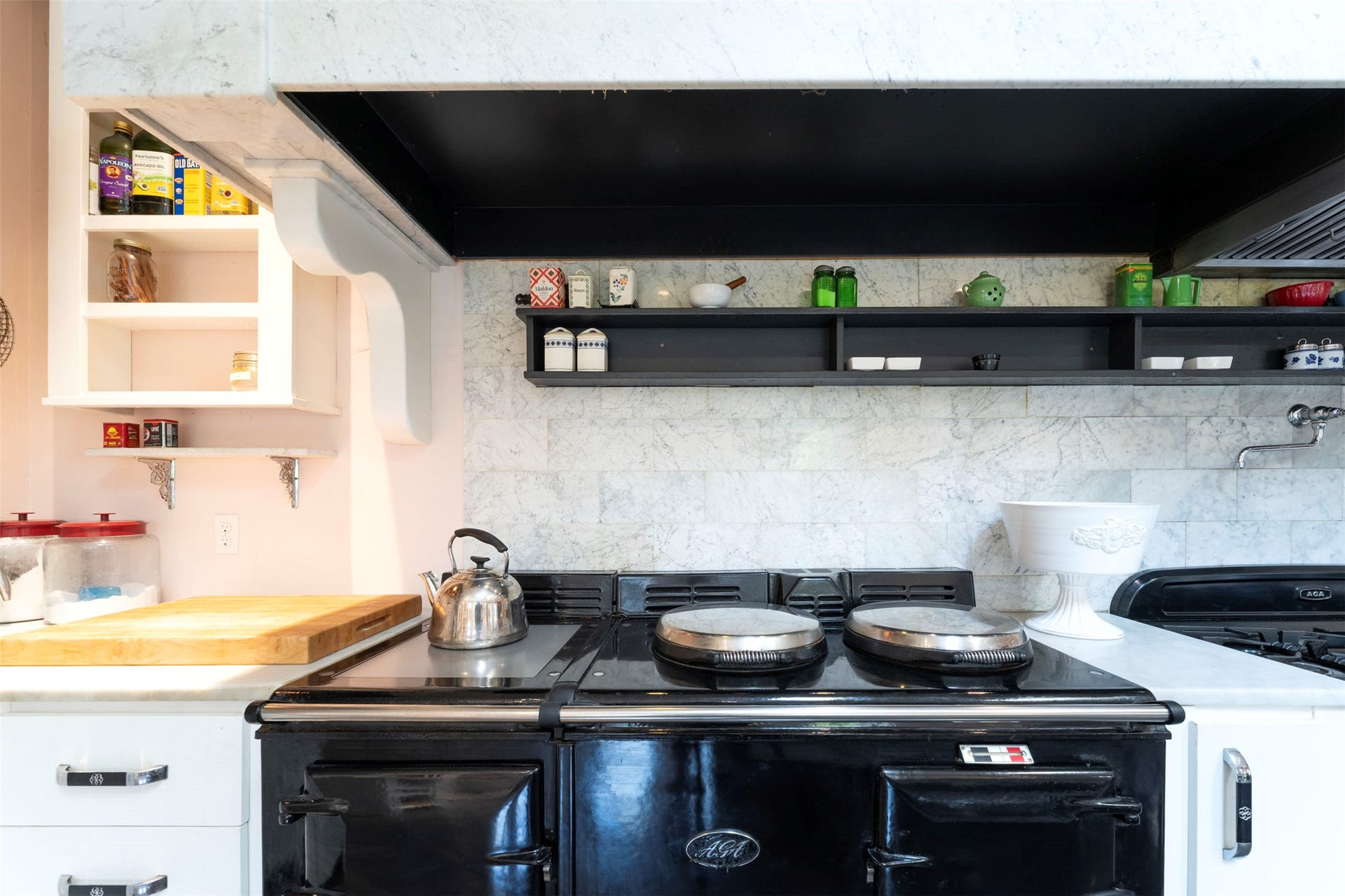 21848 Mt Highway 35, Bigfork, MT 59911 The heart of this home's kitchen is an English Aga black enamel oven. cooker, white marble countertops, and a full-height tile backsplash