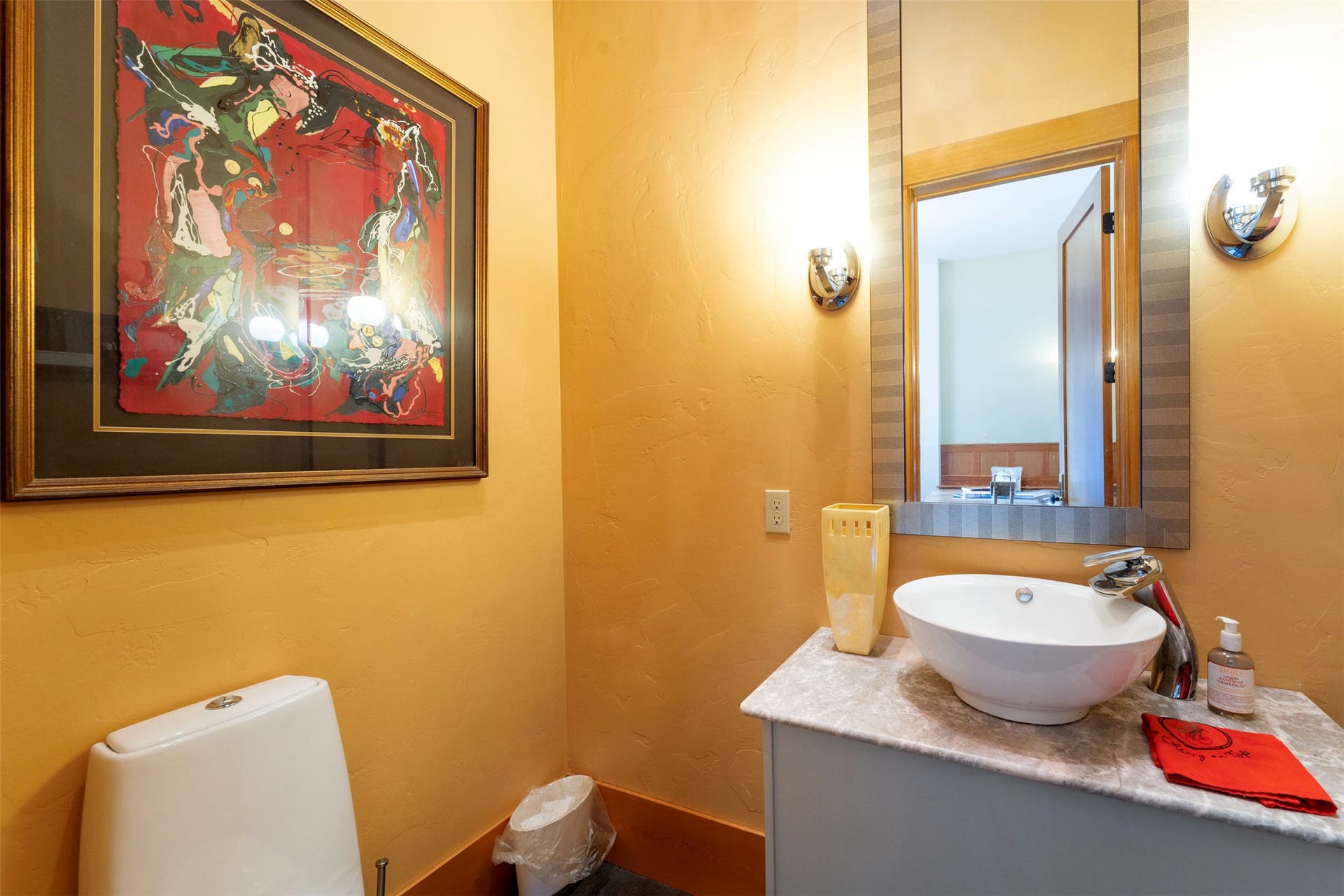 21848 Mt Highway 35, Bigfork, MT 59911 Vanity area featuring a vessel sink, stone-finish countertop, and wall-mounted light fixtures