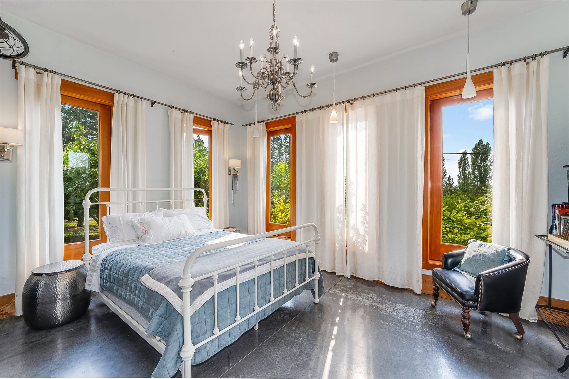 21848 Mt Highway 35, Bigfork, MT 59911 Spacious guest bedroom featuring multiple large windows with wood frames, dark flooring, a chandelier, and recessed lighting