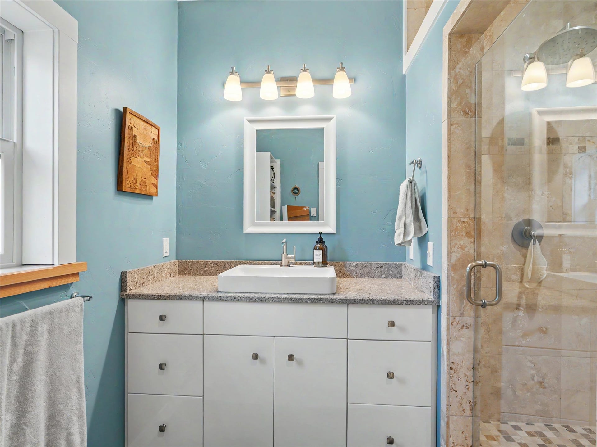 28012 Meadow Creek Road, Bigfork, MT 59911 Primary 3/4 bathroom featuring a white vanity with integrated cabinetry, a vessel sink, and a speckled countertop