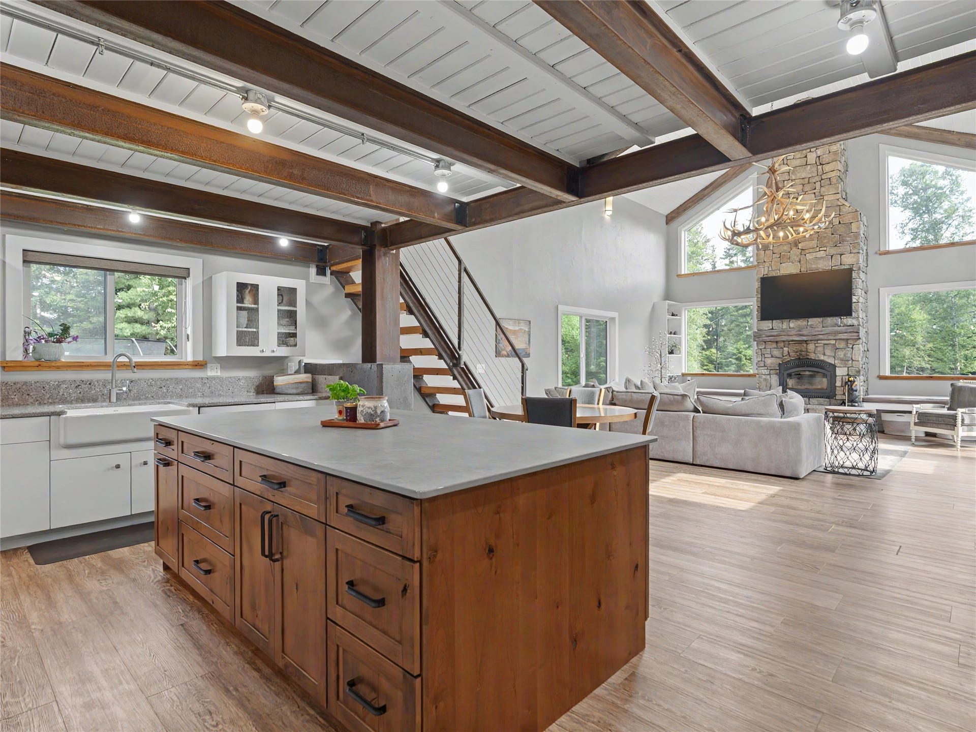 28012 Meadow Creek Road, Bigfork, MT 59911 Open-concept living space with exposed wood beams, vaulted ceiling, and wood-finish flooring