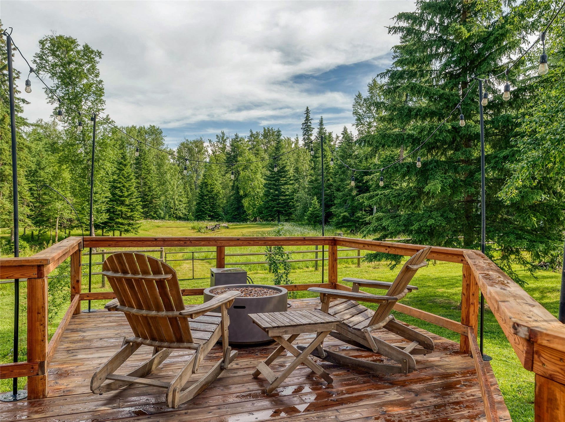 28012 Meadow Creek Road, Bigfork, MT 59911 Expansive wood deck with a natural finish, featuring a wooden railing system
