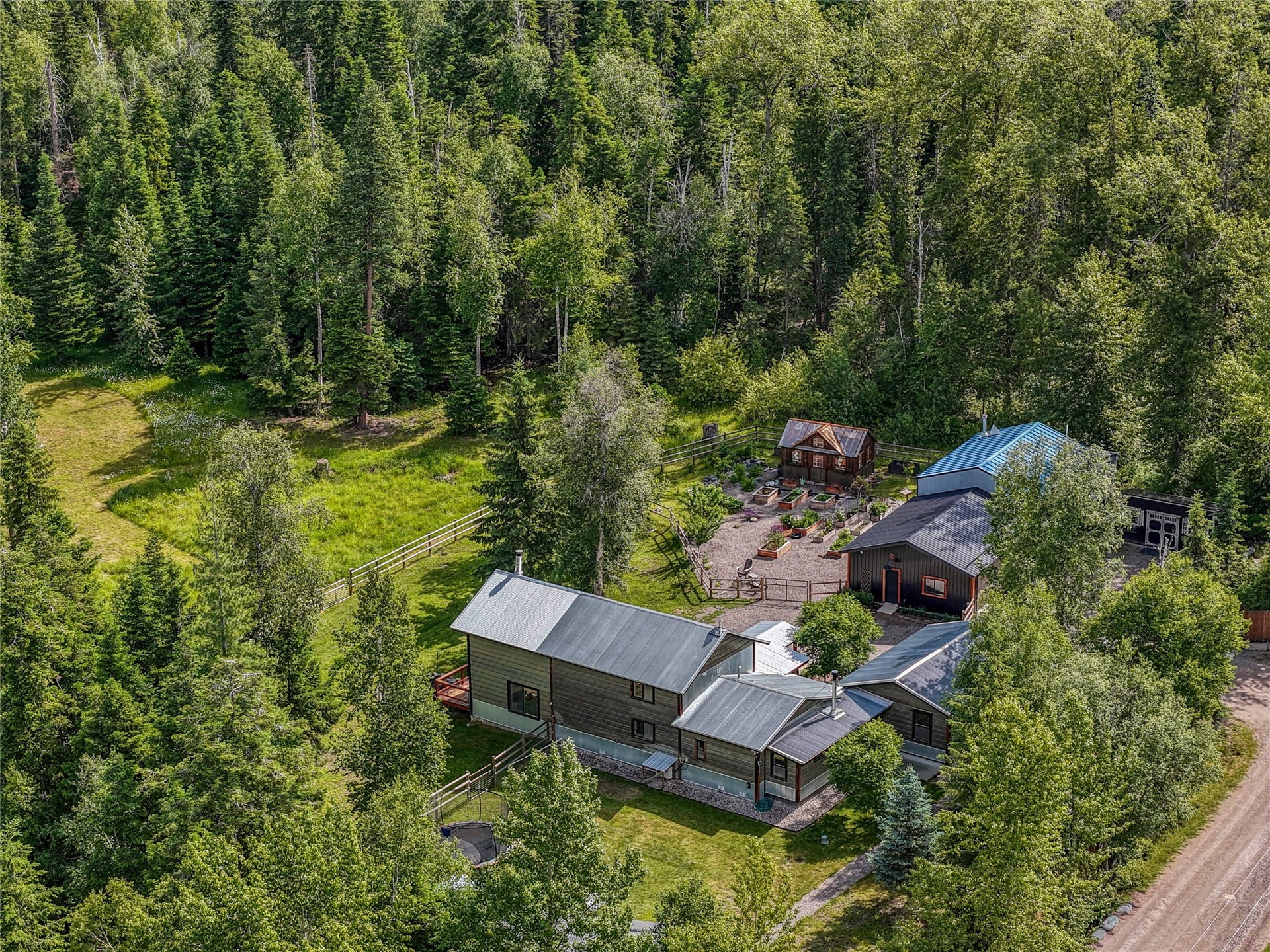 28012 Meadow Creek Road, Bigfork, MT 59911 Expansive property featuring multiple structures, surrounded by dense evergreen and deciduous trees