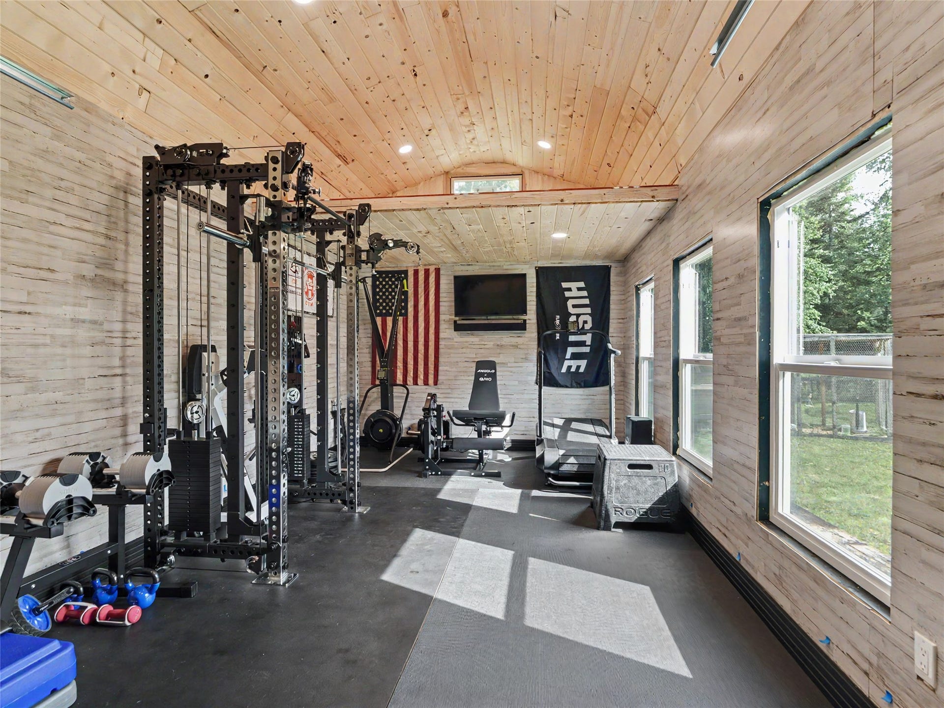 28012 Meadow Creek Road, Bigfork, MT 59911 Dedicated fitness outbuilding featuring wood-finish ceiling and walls, recessed lighting, and multiple windows