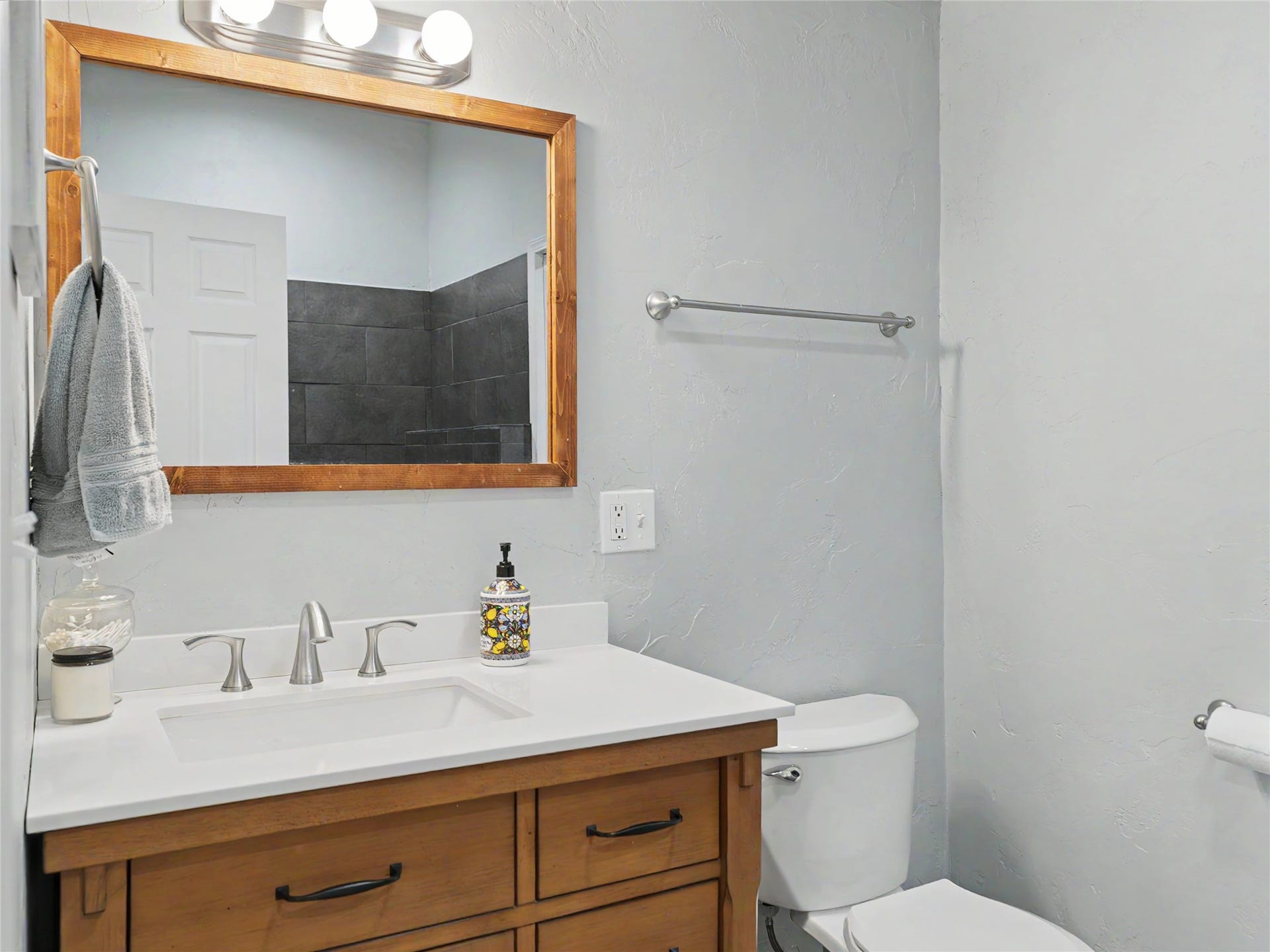 28012 Meadow Creek Road, Bigfork, MT 59911 Guest Quarters 3/4 Bathroom featuring a wood-finish vanity with a white countertop and undermount sink