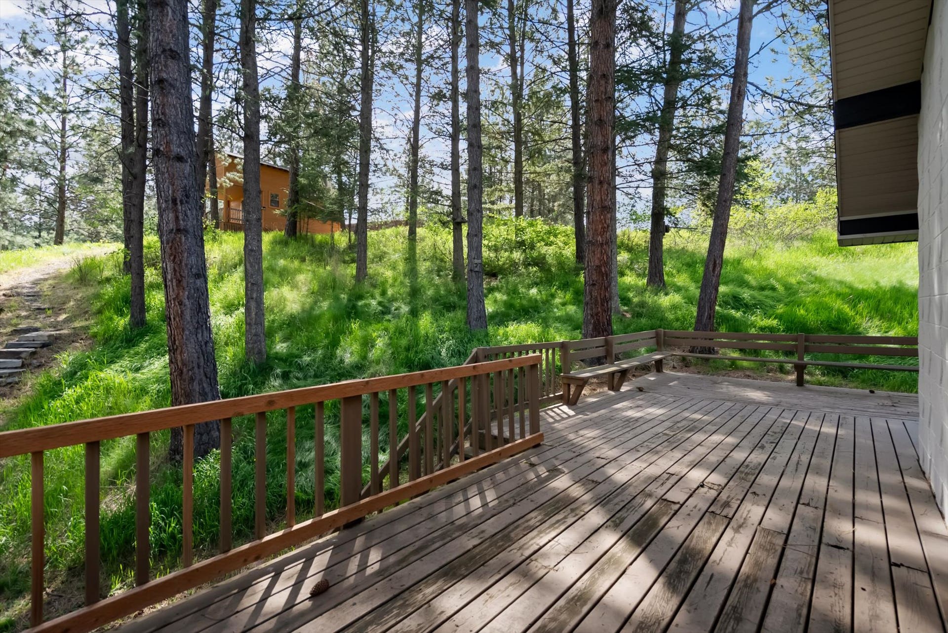 300 Peaceful Drive, Bigfork, MT 59911 Wood-plank outdoor deck featuring built-in bench seating and a wood railing