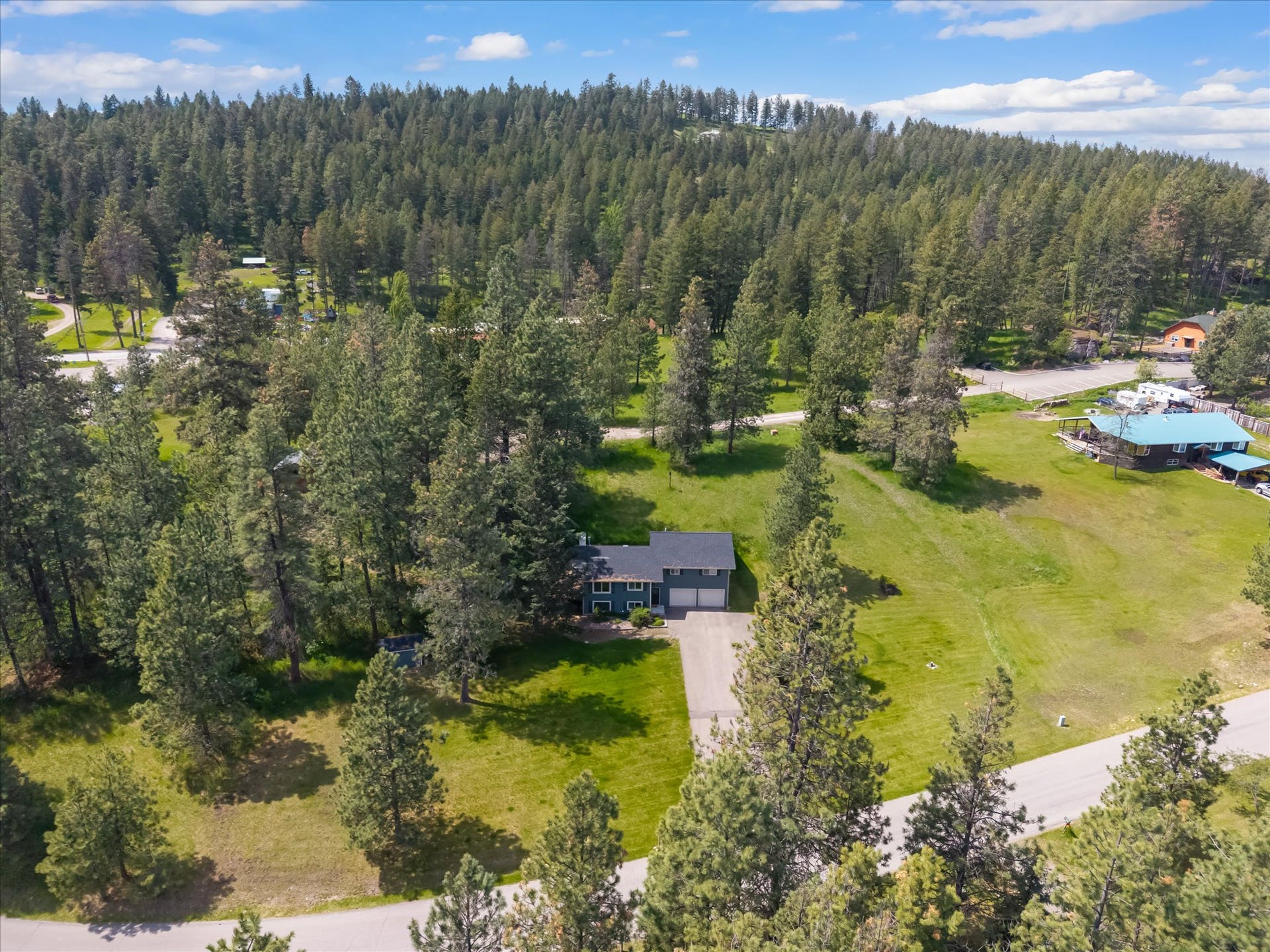 300 Peaceful Drive, Bigfork, MT 59911 Split-level residence featuring a dark gray roof and light-colored siding