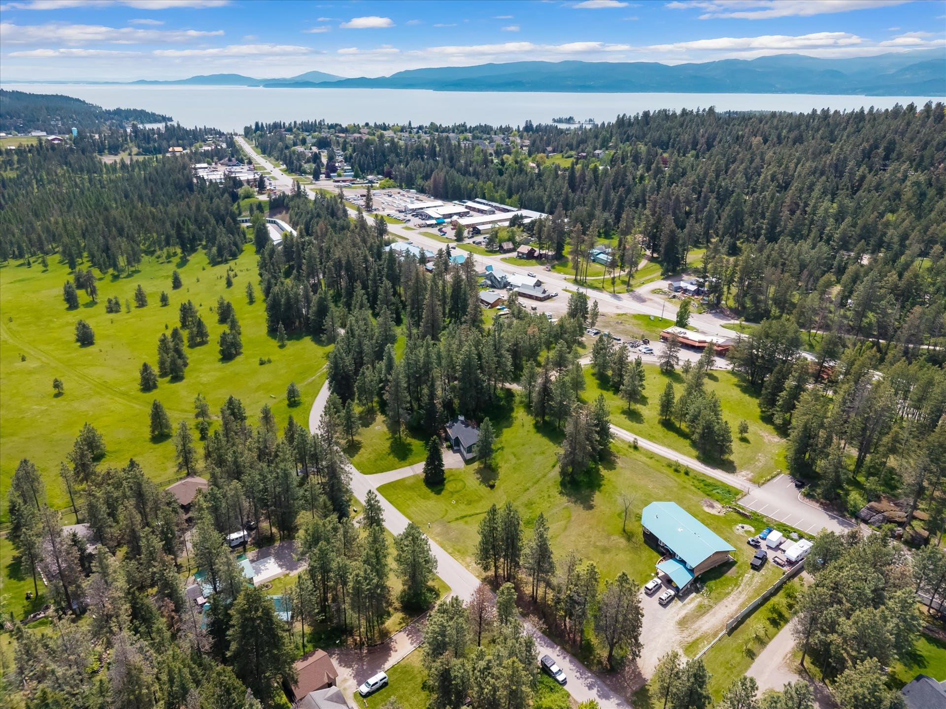 300 Peaceful Drive, Bigfork, MT 59911 Expansive aerial view showcasing a verdant landscape with extensive tree coverage and open grassy areas