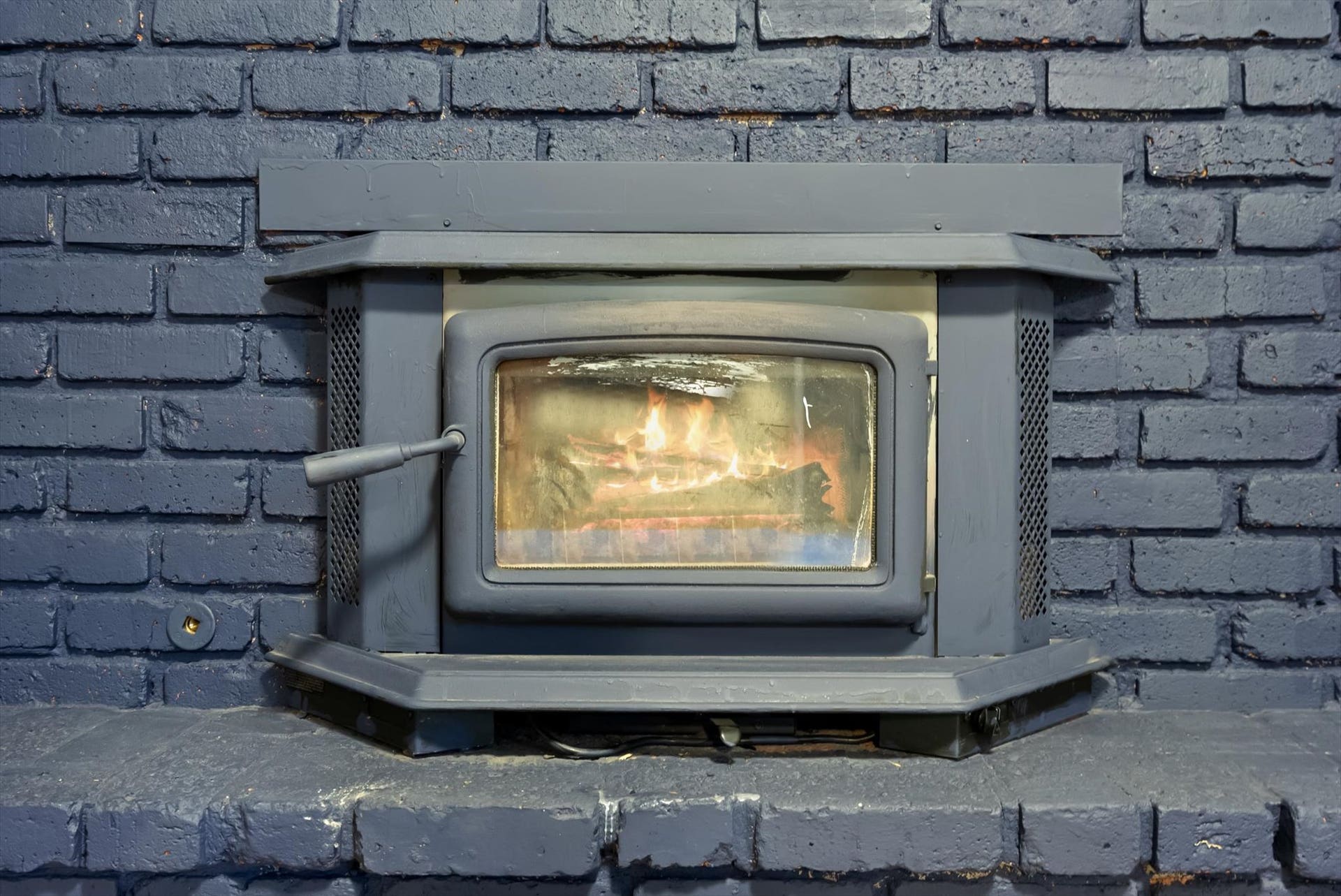 300 Peaceful Drive, Bigfork, MT 59911 Wood-burning fireplace insert set within a painted brick surround and hearth