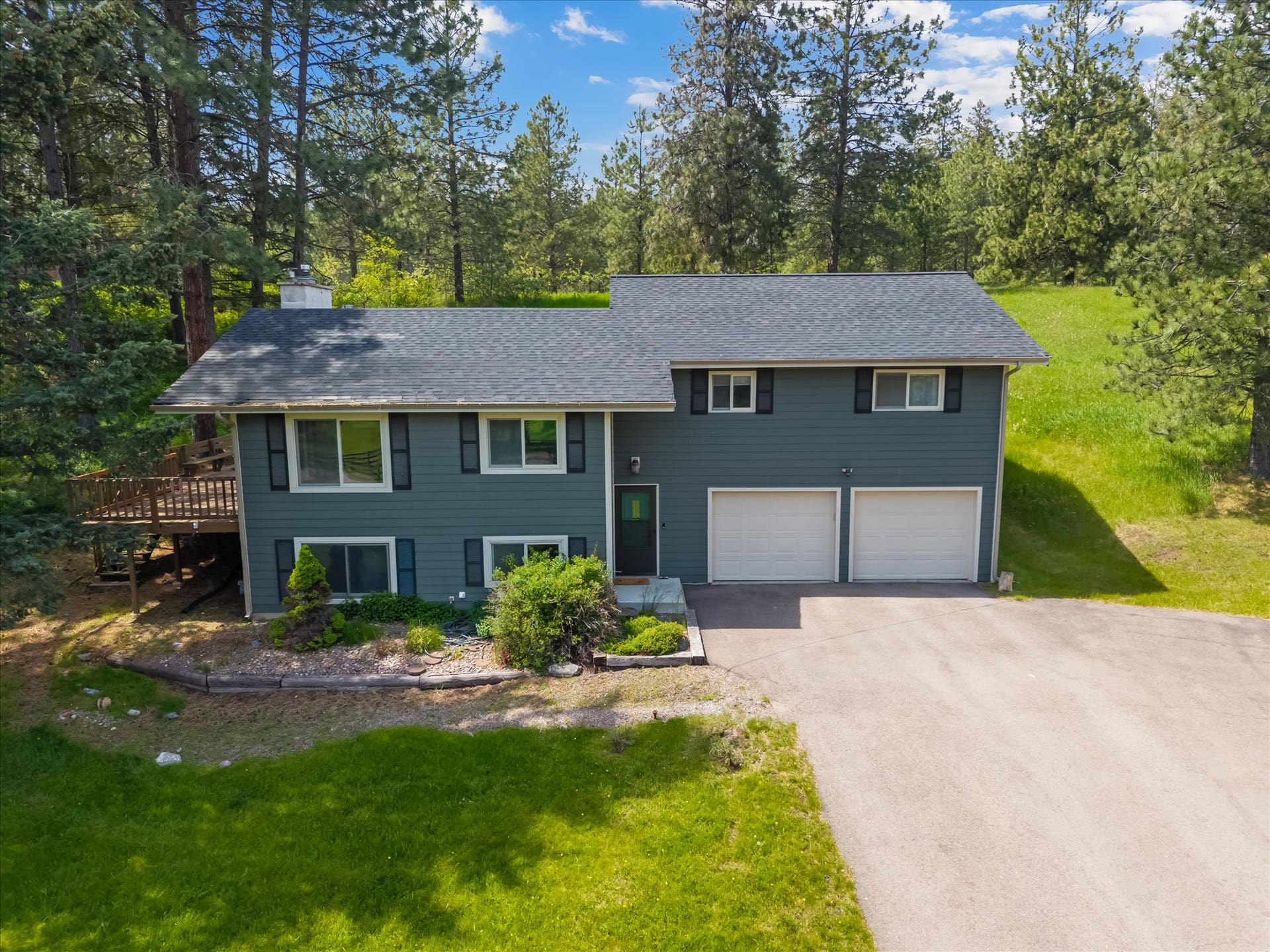 300 Peaceful Drive, Bigfork, MT 59911 Split-level residence featuring a gray exterior siding and a dark gray roof