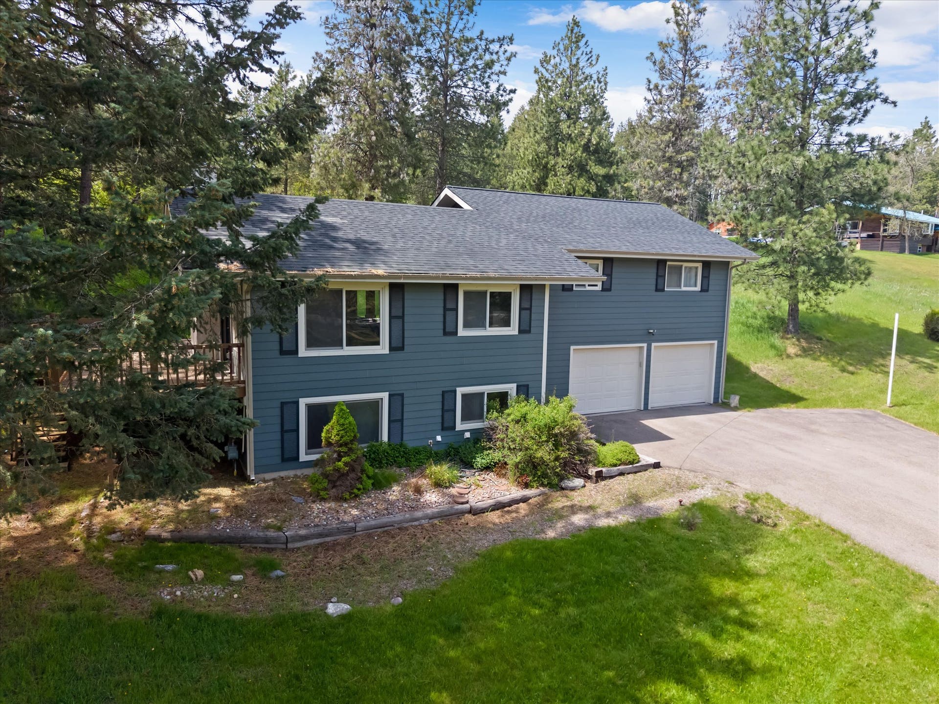300 Peaceful Drive, Bigfork, MT 59911 Split-level residence featuring blue siding with white trim and dark shutters
