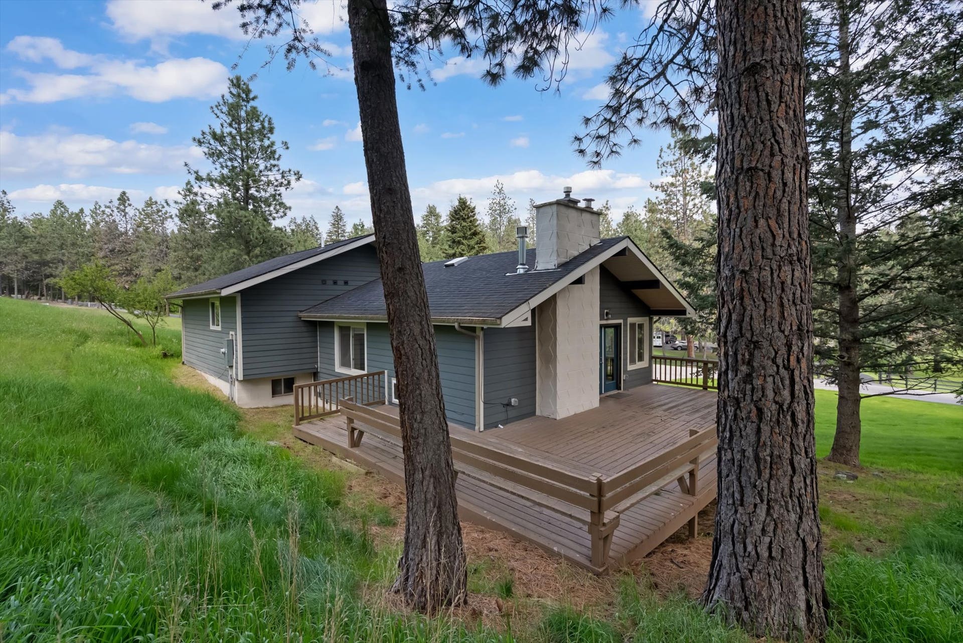 300 Peaceful Drive, Bigfork, MT 59911 Expansive wood-finish deck with integrated bench seating and dark railing