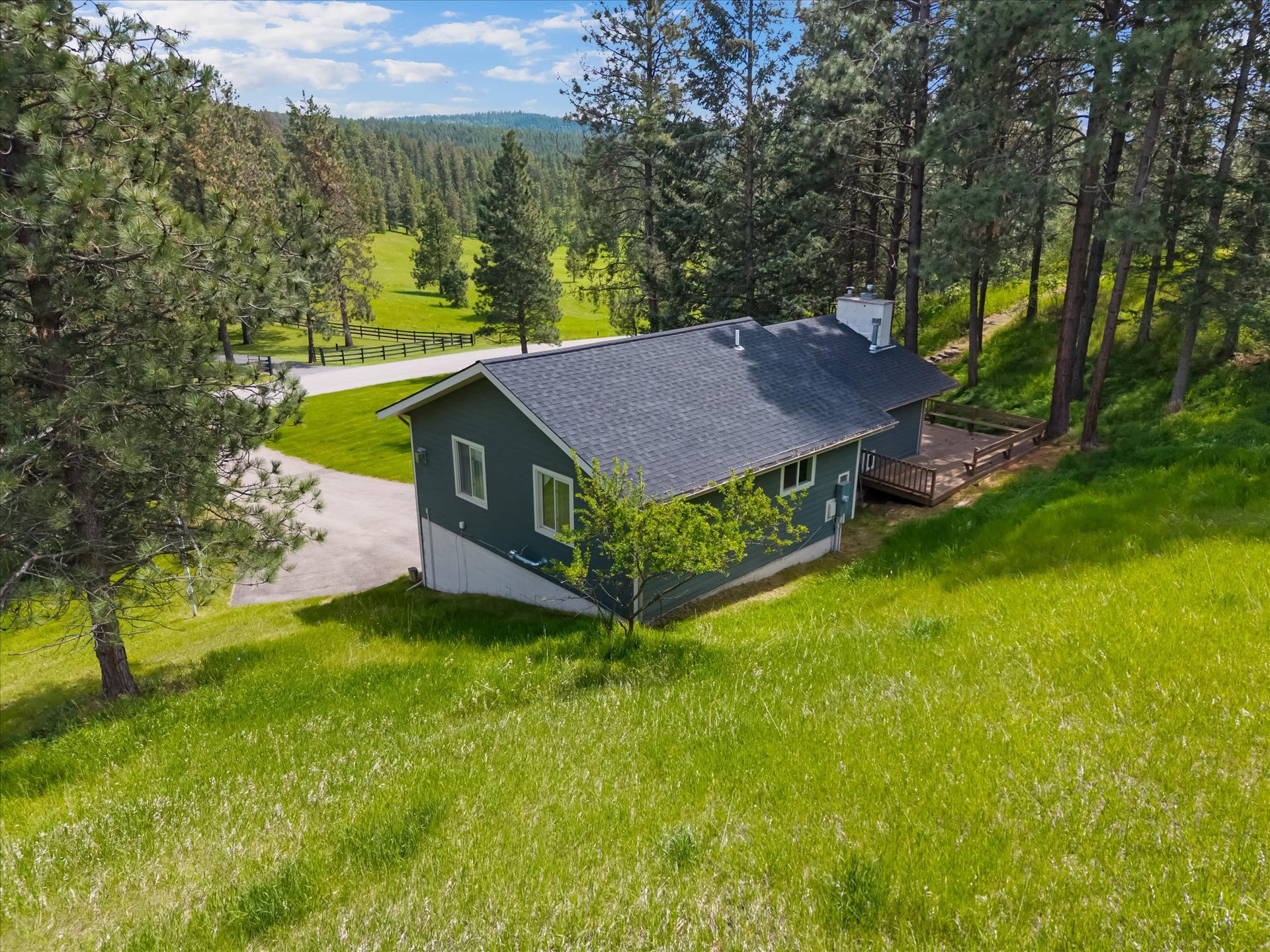 300 Peaceful Drive, Bigfork, MT 59911 Single-story residence featuring a dark blue facade and a gray shingle roof