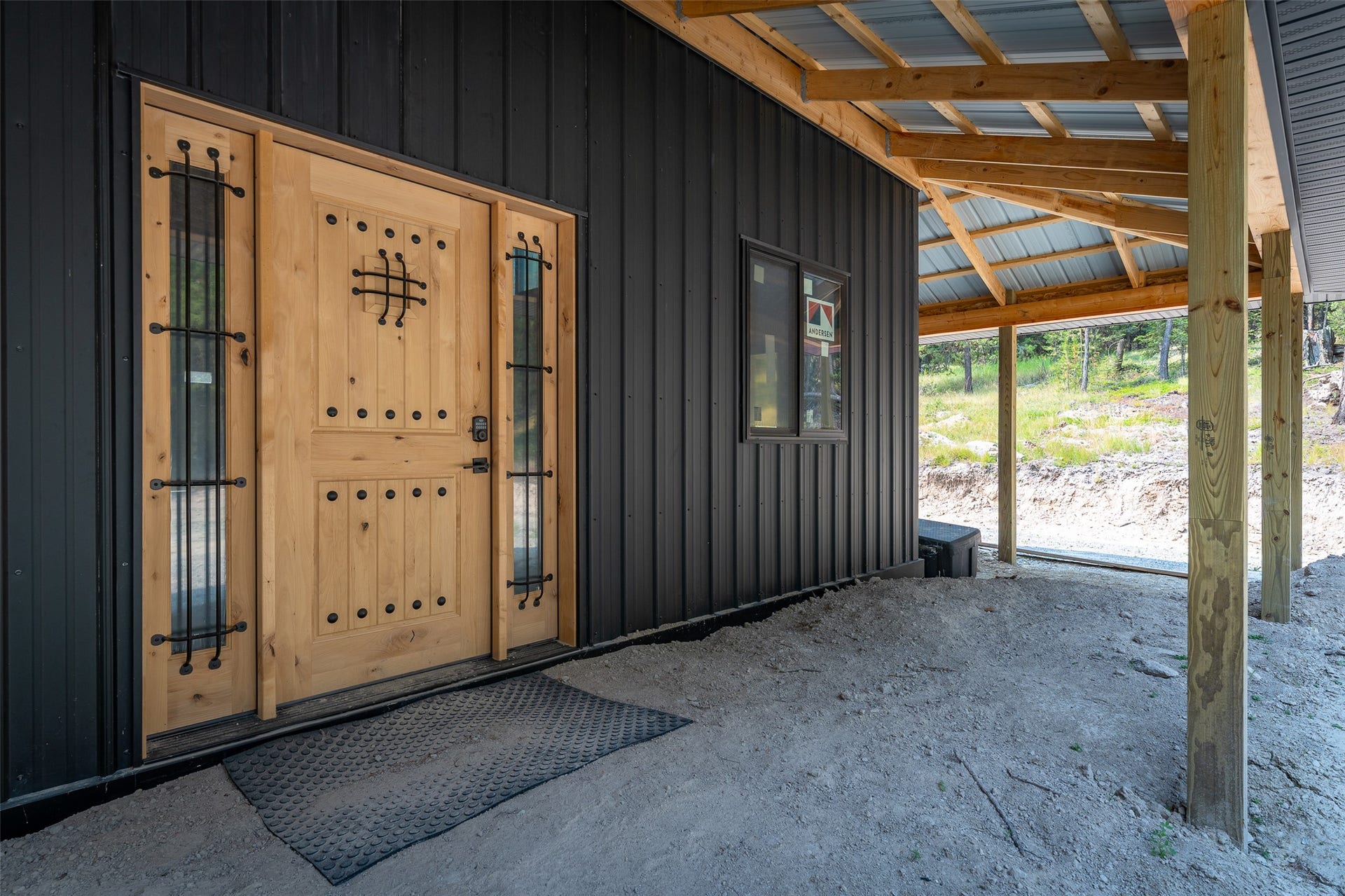 9653 Us Highway 2 W, Marion, MT 59925 Wood-finish entry door with decorative ironwork and side-light windows