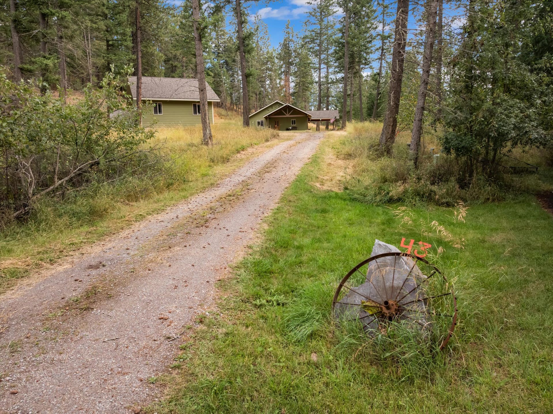 43 Peaceful Court, Bigfork, MT 59911 Gravel driveway, surrounded by mature trees and natural landscaping