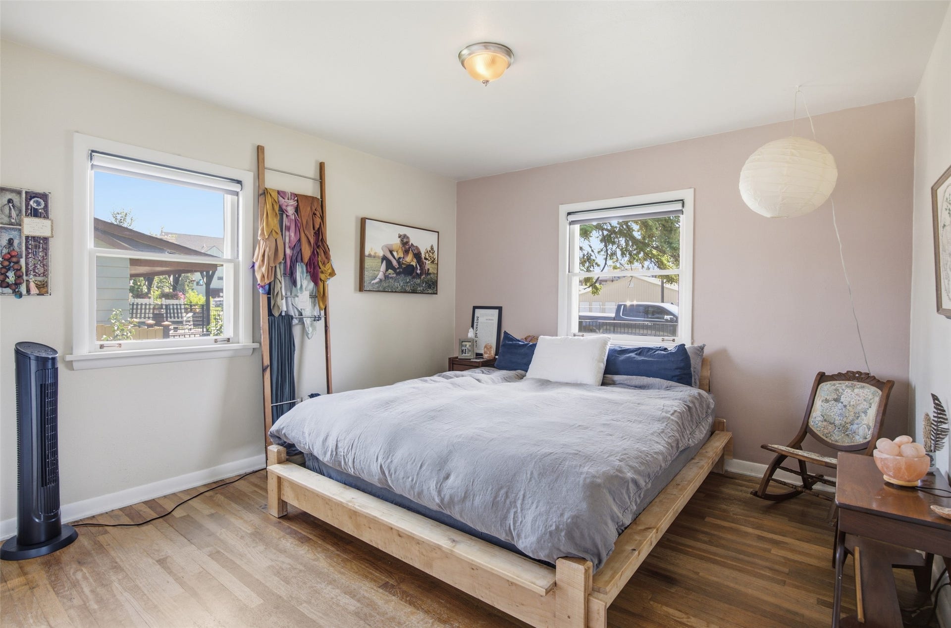 Wood-finish flooring with a flush-mount ceiling light fixture, two single-hung windows, and light-colored walls