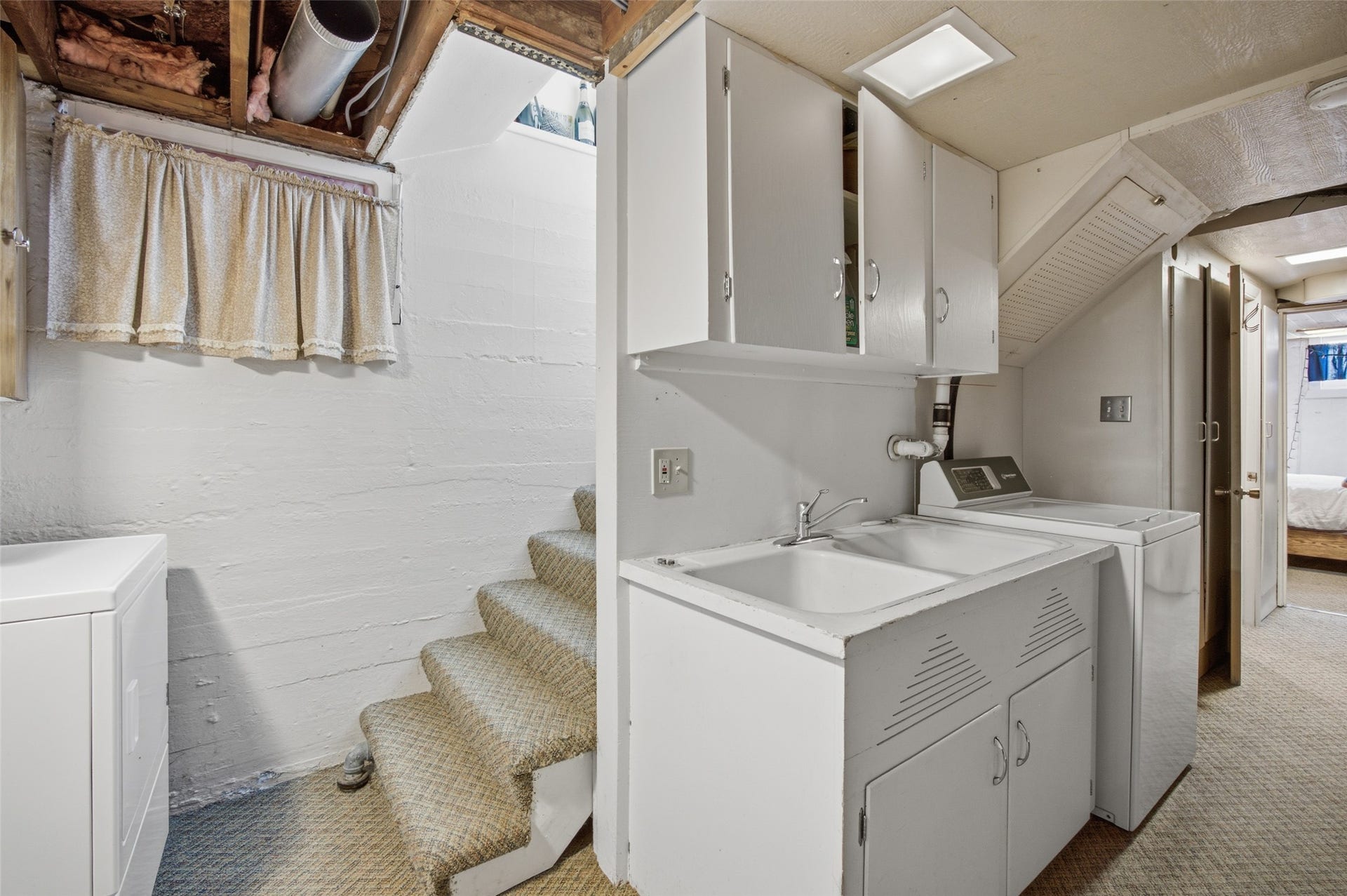Utility area with a double basin sink, white cabinetry, and recessed lighting