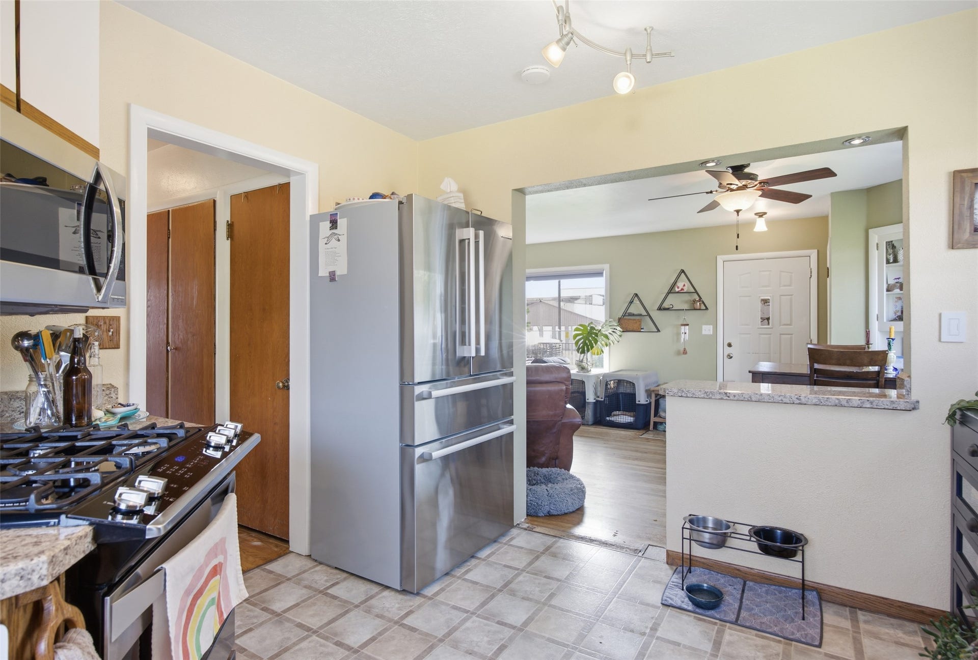 Kitchen featuring tile flooring, built-in microwave, gas range, and a breakfast bar with a stone-finish countertop