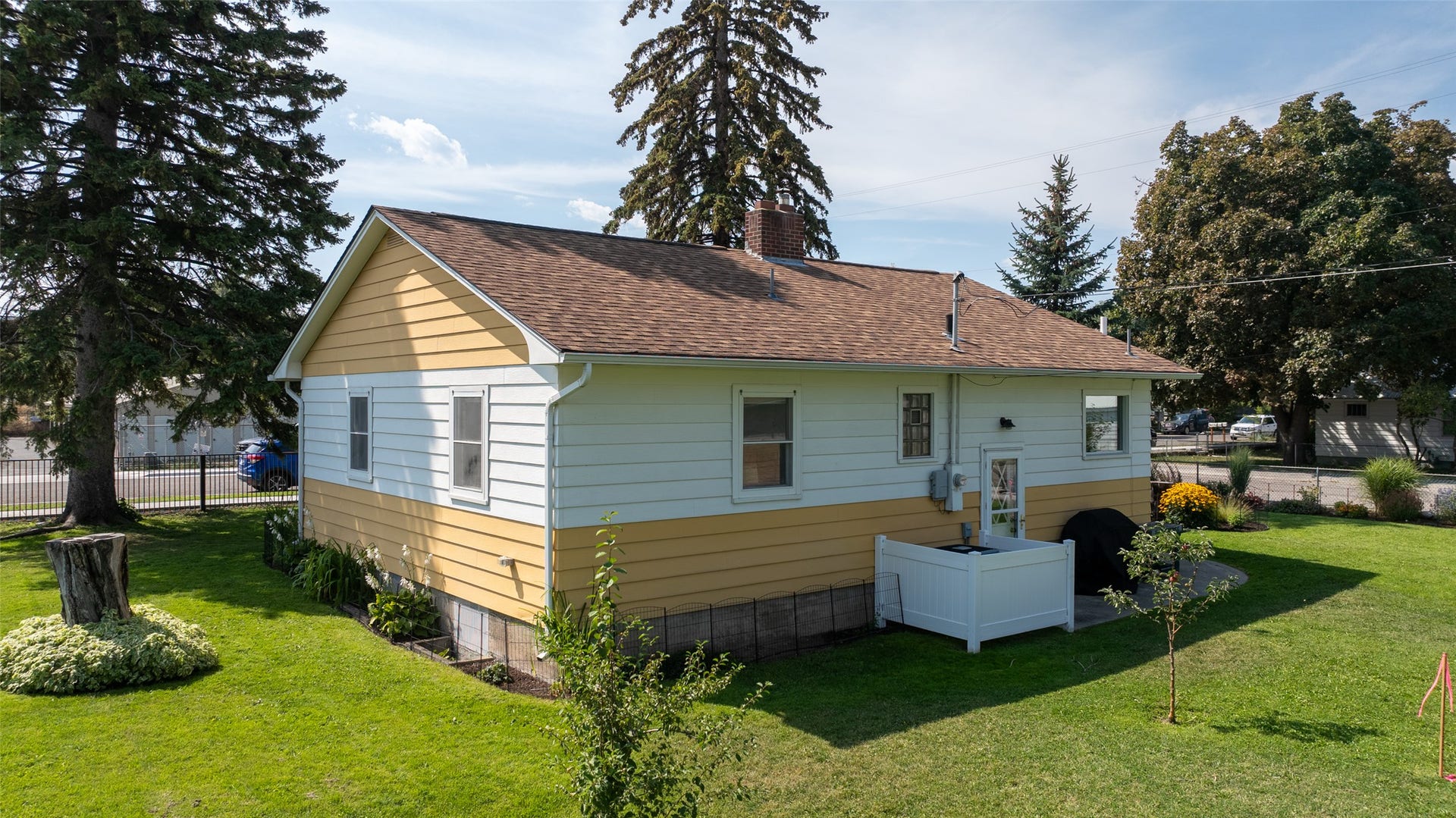 White and yellow horizontal siding exterior with a brown shingle roof