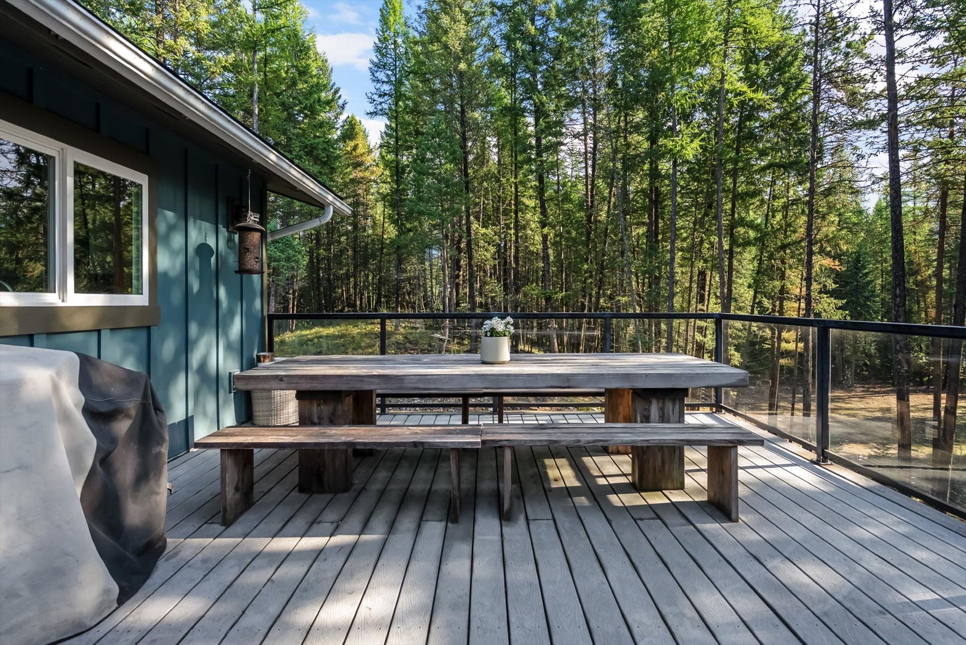 Designed for seamless outdoor living, the expansive deck features sleek glass and metal railings to ensure zero visual barriers between you and your private 4.79-acre estate.