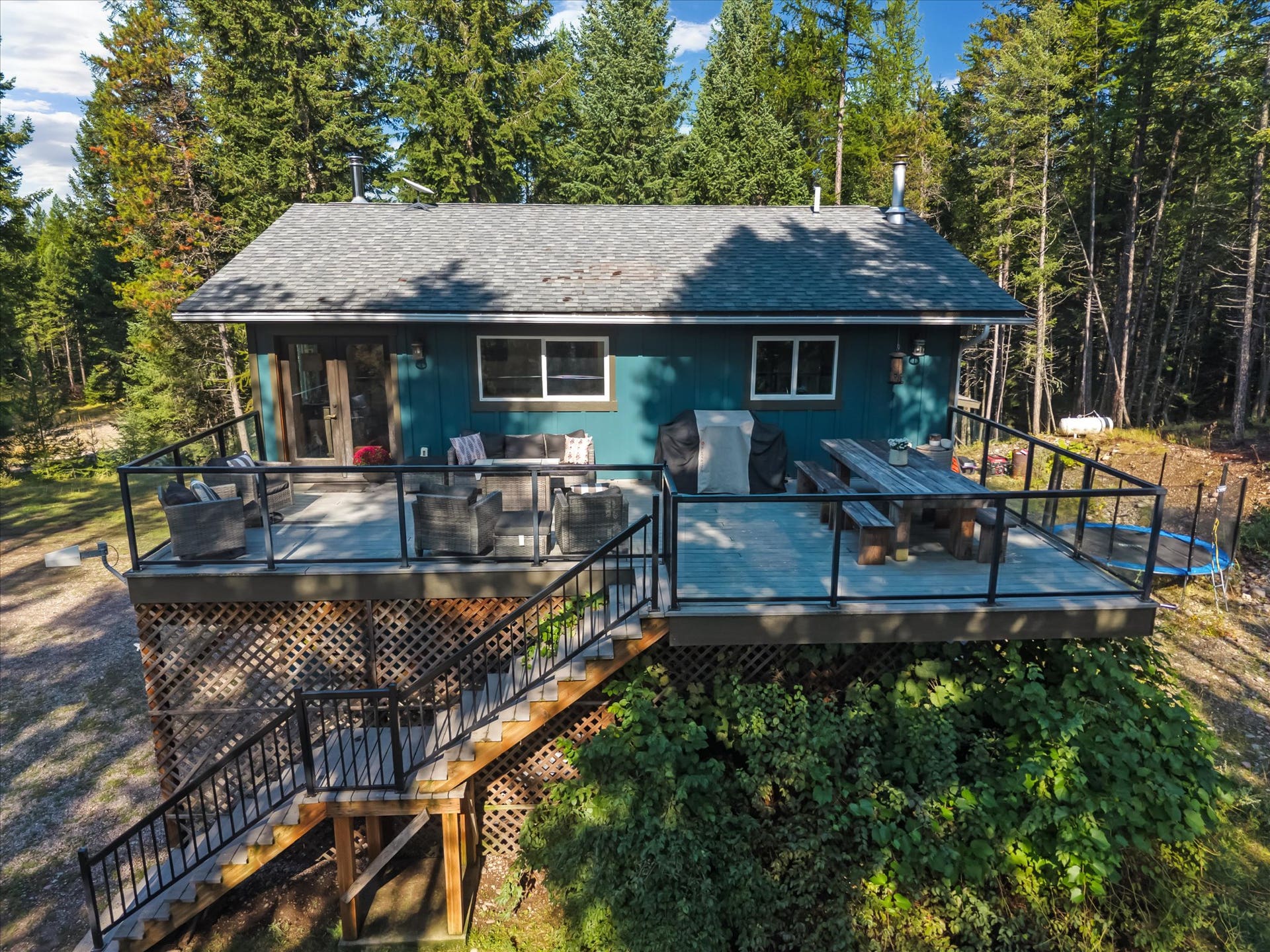 Designed for seamless outdoor living, the expansive deck features sleek glass and metal railings to ensure zero visual barriers between you and your private 4.79-acre estate.