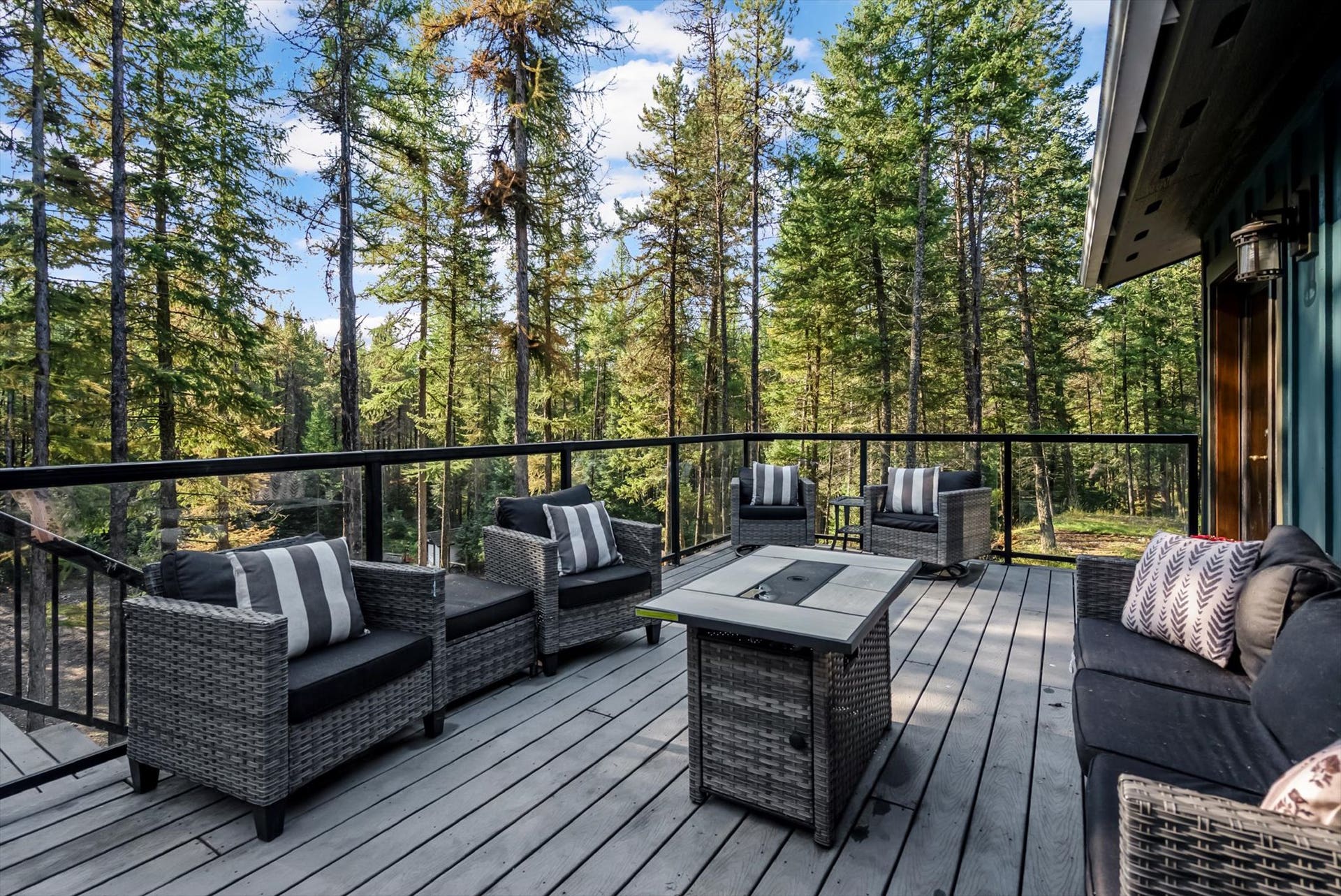Designed for seamless outdoor living, the expansive deck features sleek glass and metal railings to ensure zero visual barriers between you and your private 4.79-acre estate.