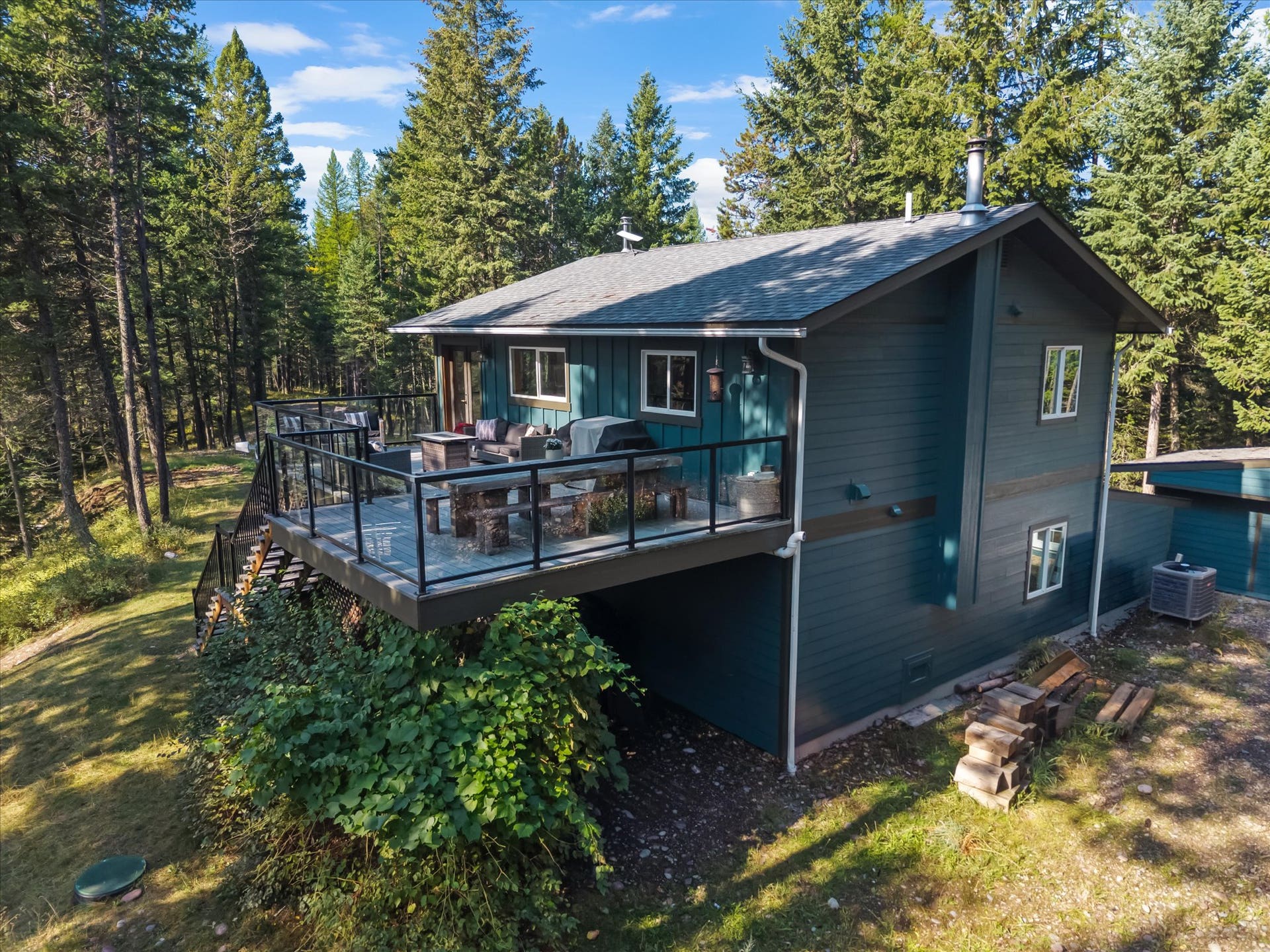 Designed for seamless outdoor living, the expansive deck features sleek glass and metal railings to ensure zero visual barriers between you and your private 4.79-acre estate.