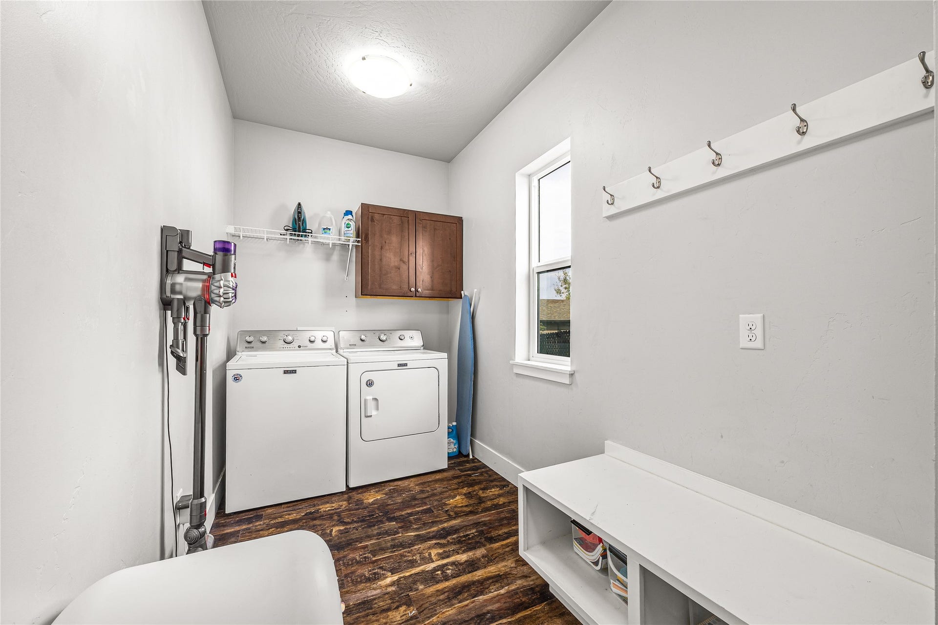 Wood-finish flooring with a side-by-side laundry appliance setup