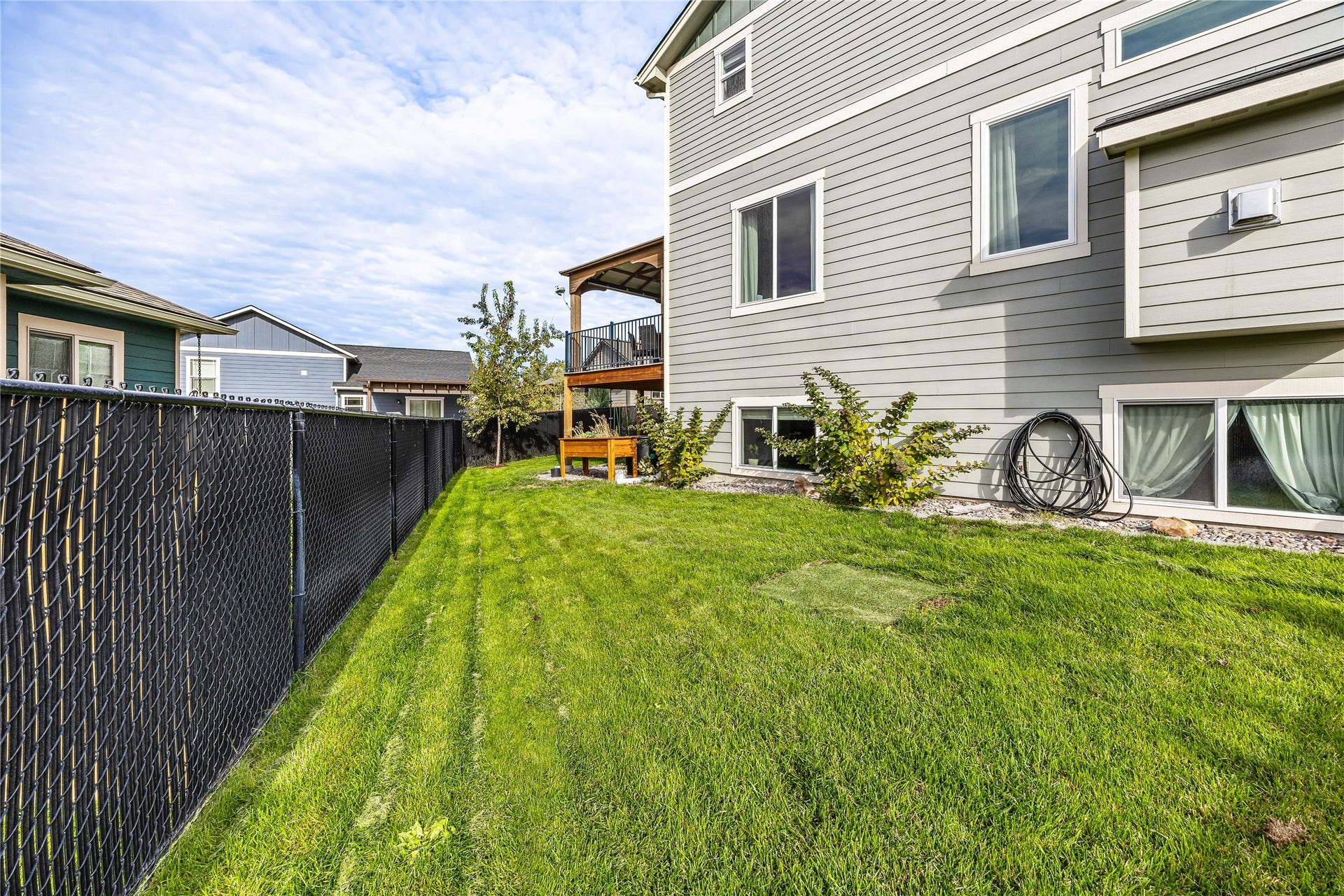 Expansive lawn featuring a black chain-link fence