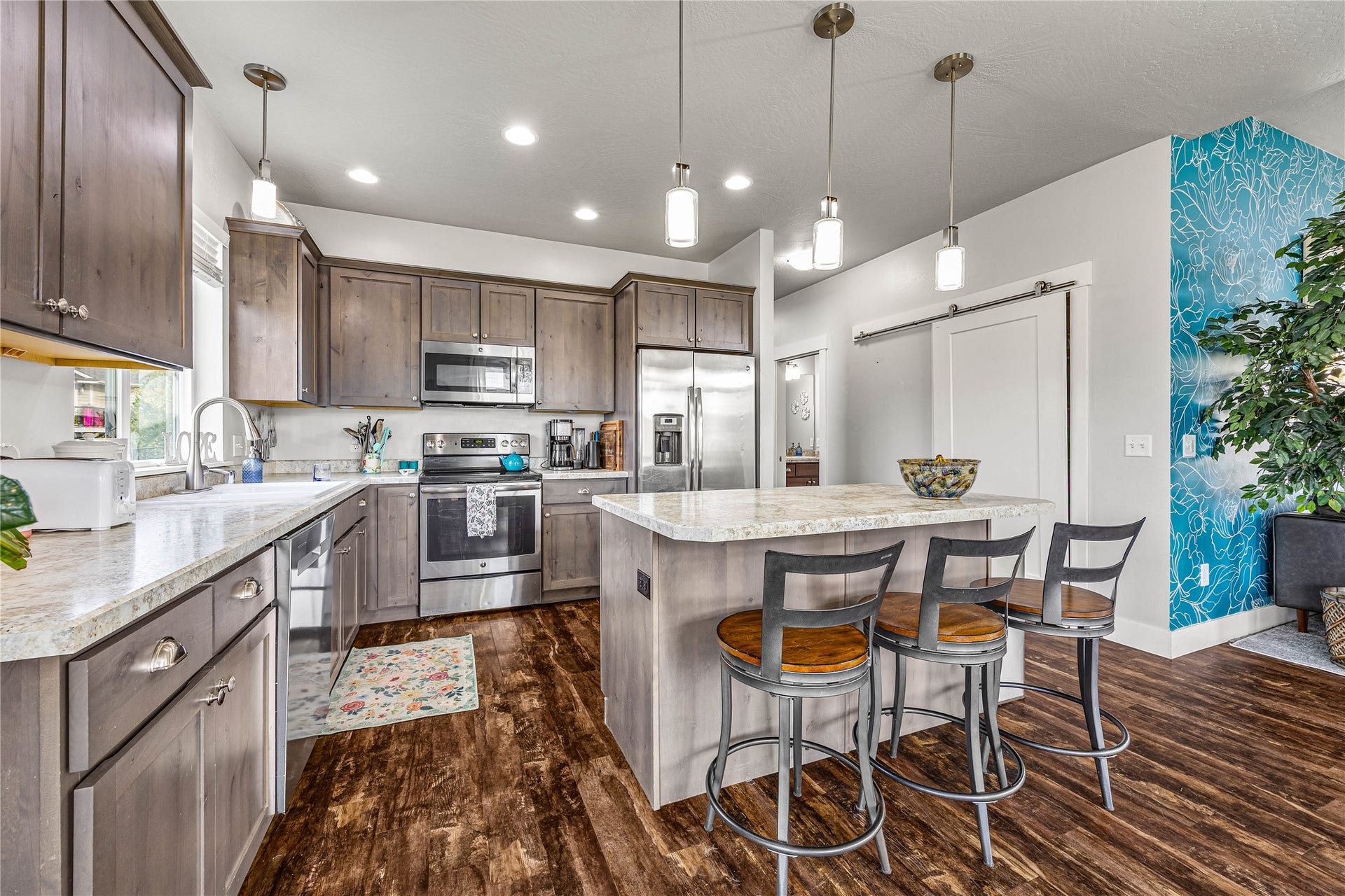 Kitchen featuring wood-finish flooring, recessed lighting, and an island with pendant lights