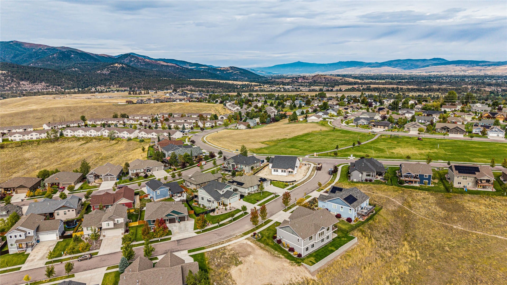 Established neighborhood with varied architectural styles and mountain backdrops