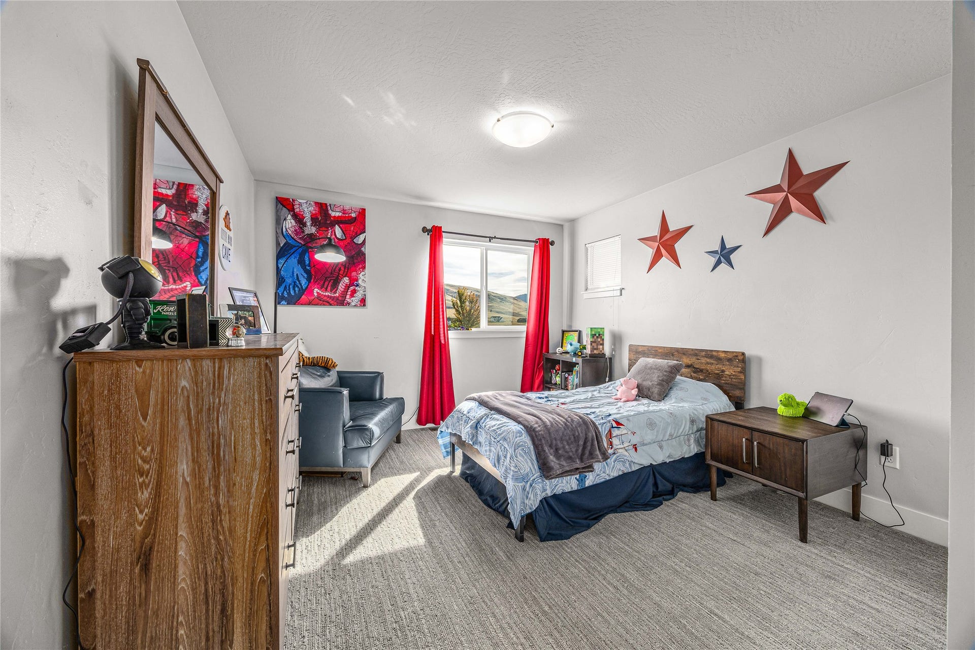 Recessed lighting, light gray carpet flooring, window with red drapery, and a wooden bed frame