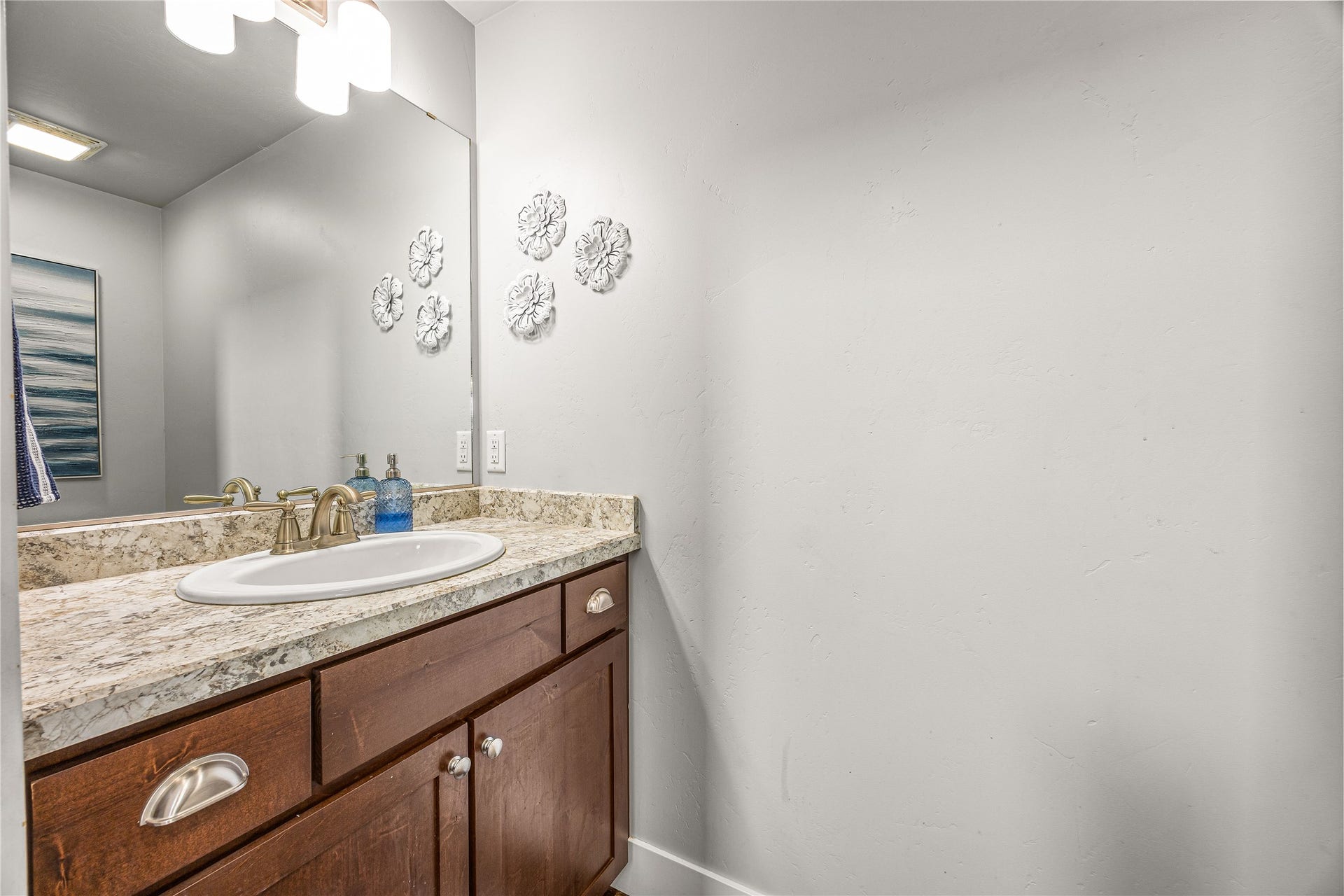 Vanity with a light-colored countertop, an undermount sink, and a brushed nickel faucet