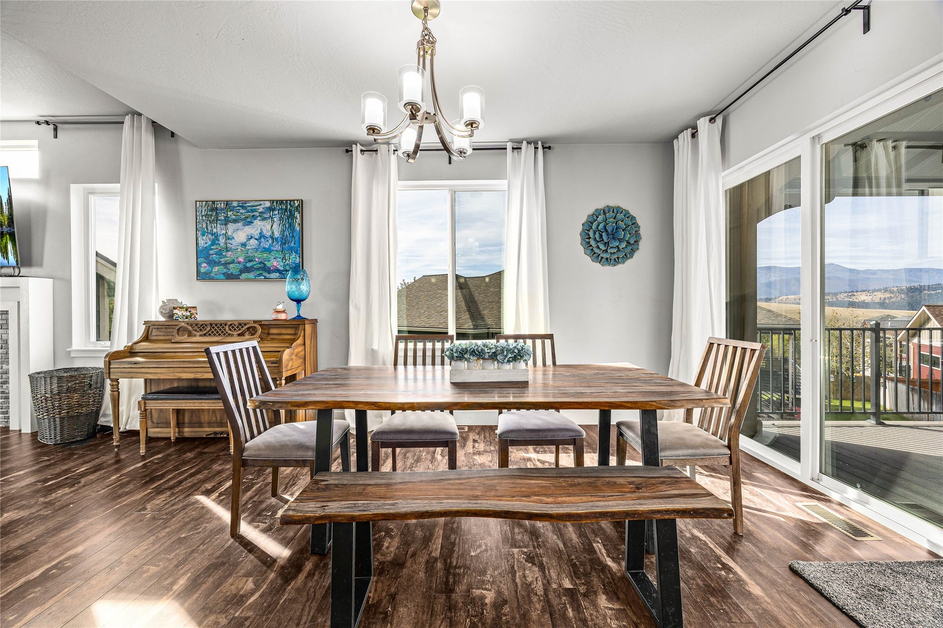Wood-finish flooring, white walls, and a chandelier with five light sources