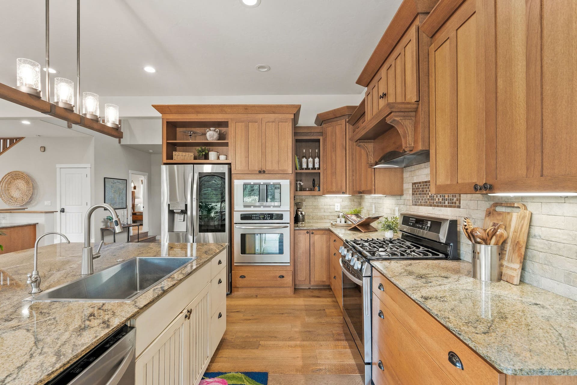 687 N Valley Drive, Whitefish, MT 59937 Kitchen includes an impressive appliance package with stainless double ovens, a gas range with custom built-in hood, microwave, French-door refrigerator and dishwasher in the island.