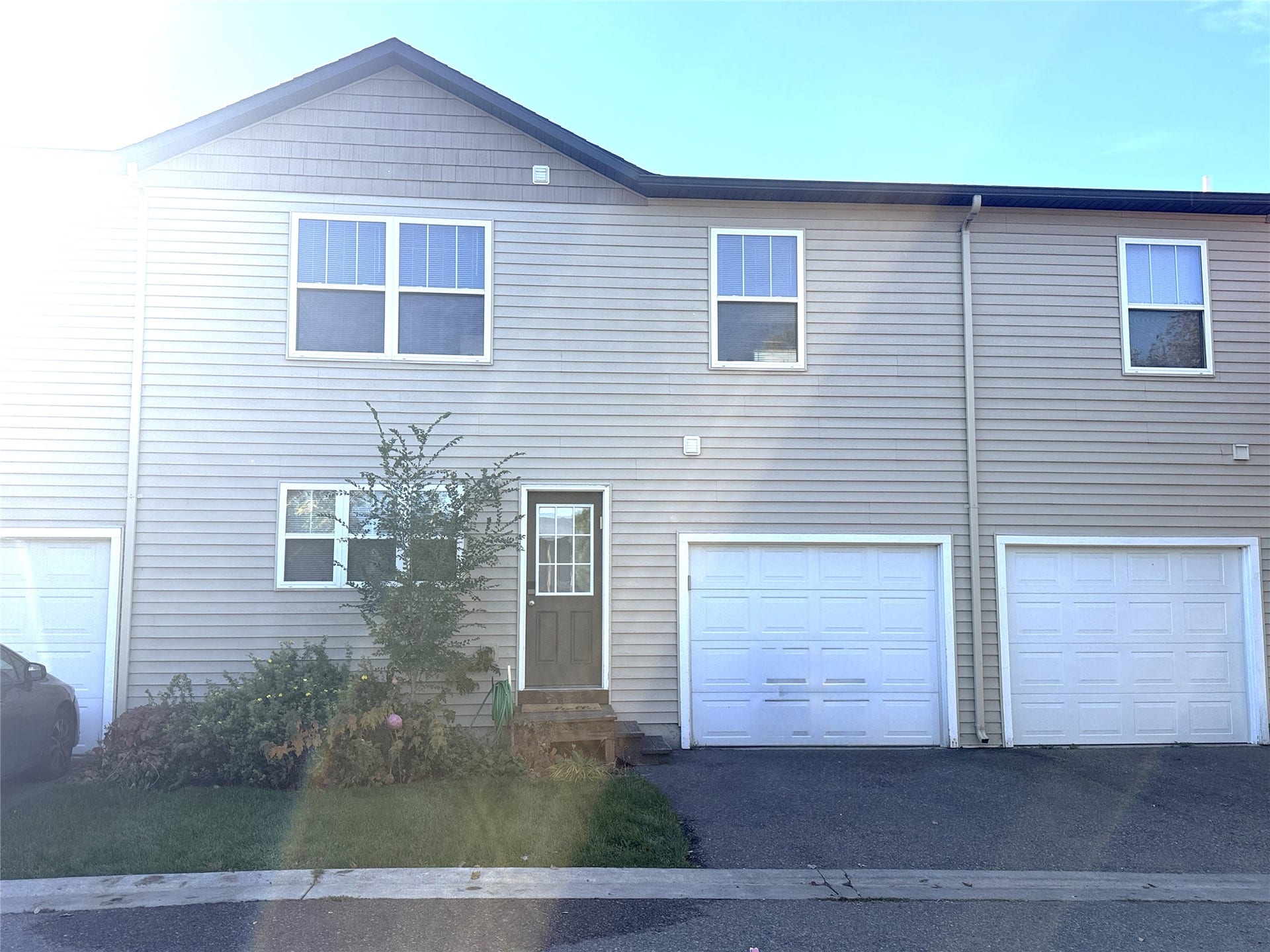 Multi-level exterior with light-colored horizontal siding and dark trim
