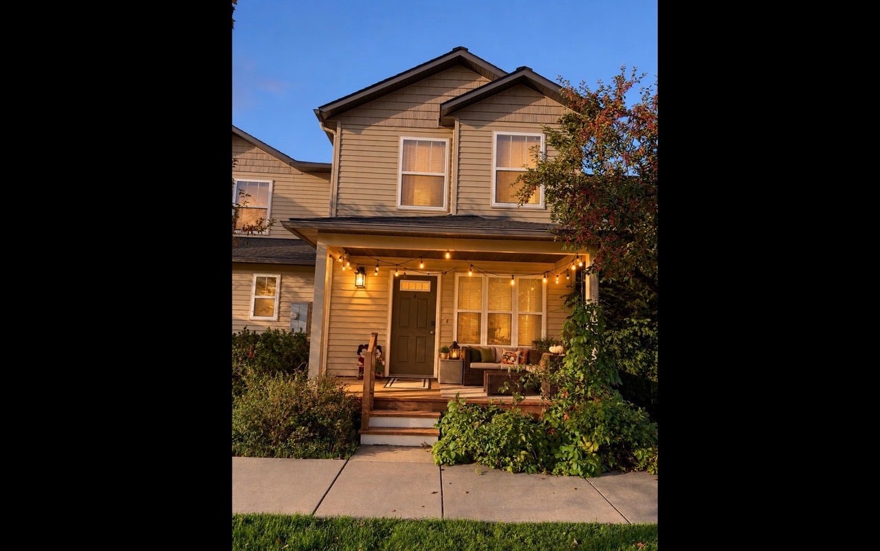 Two-story residence featuring horizontal siding, a covered front porch with exposed wood columns, and a dark-toned entry door