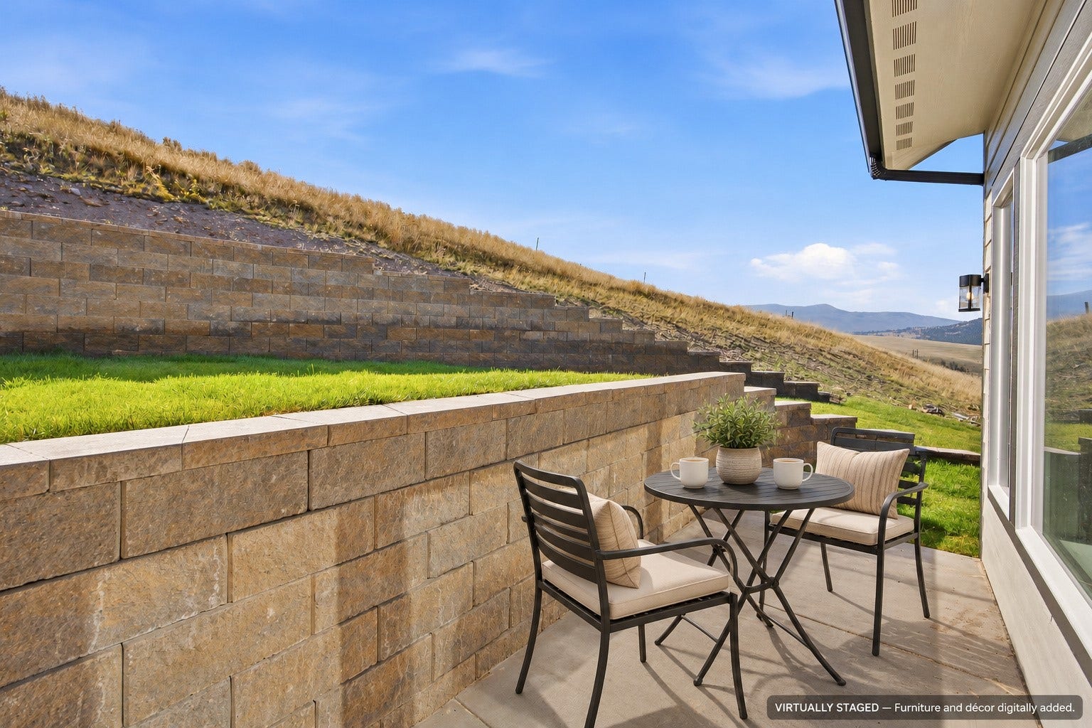 Paved patio area, stepped retaining walls, exterior wall lantern, and expansive hillside scenery