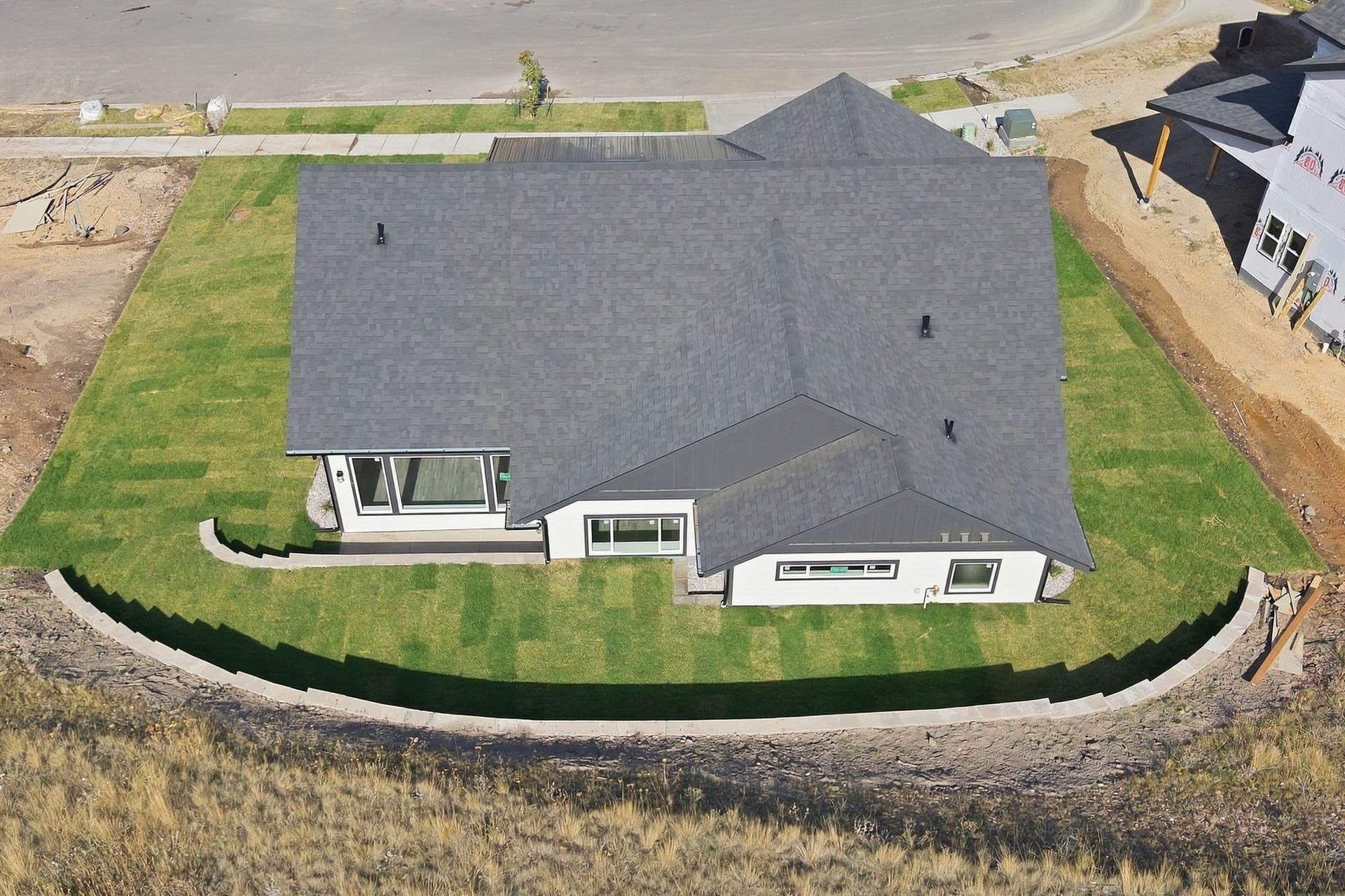 Contemporary exterior with a dark shingle roof and white siding
