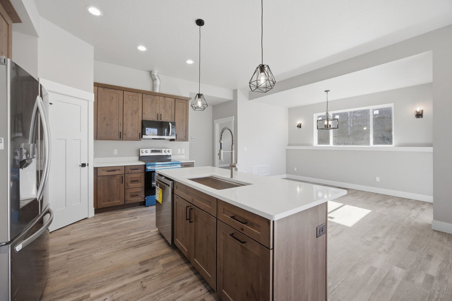 Kitchen with wood-finish flooring, white countertops, and dark-toned cabinetry