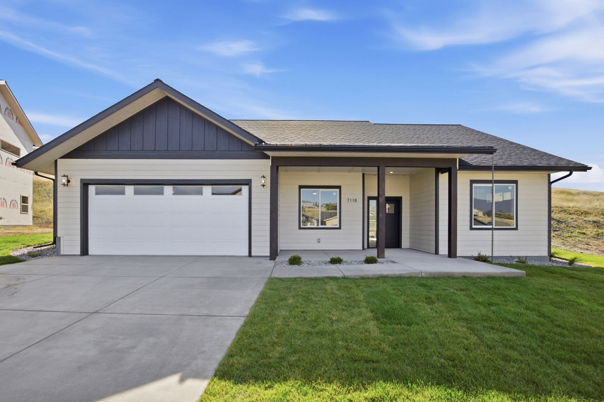 Contemporary ranch-style exterior with light-toned siding and dark trim accents