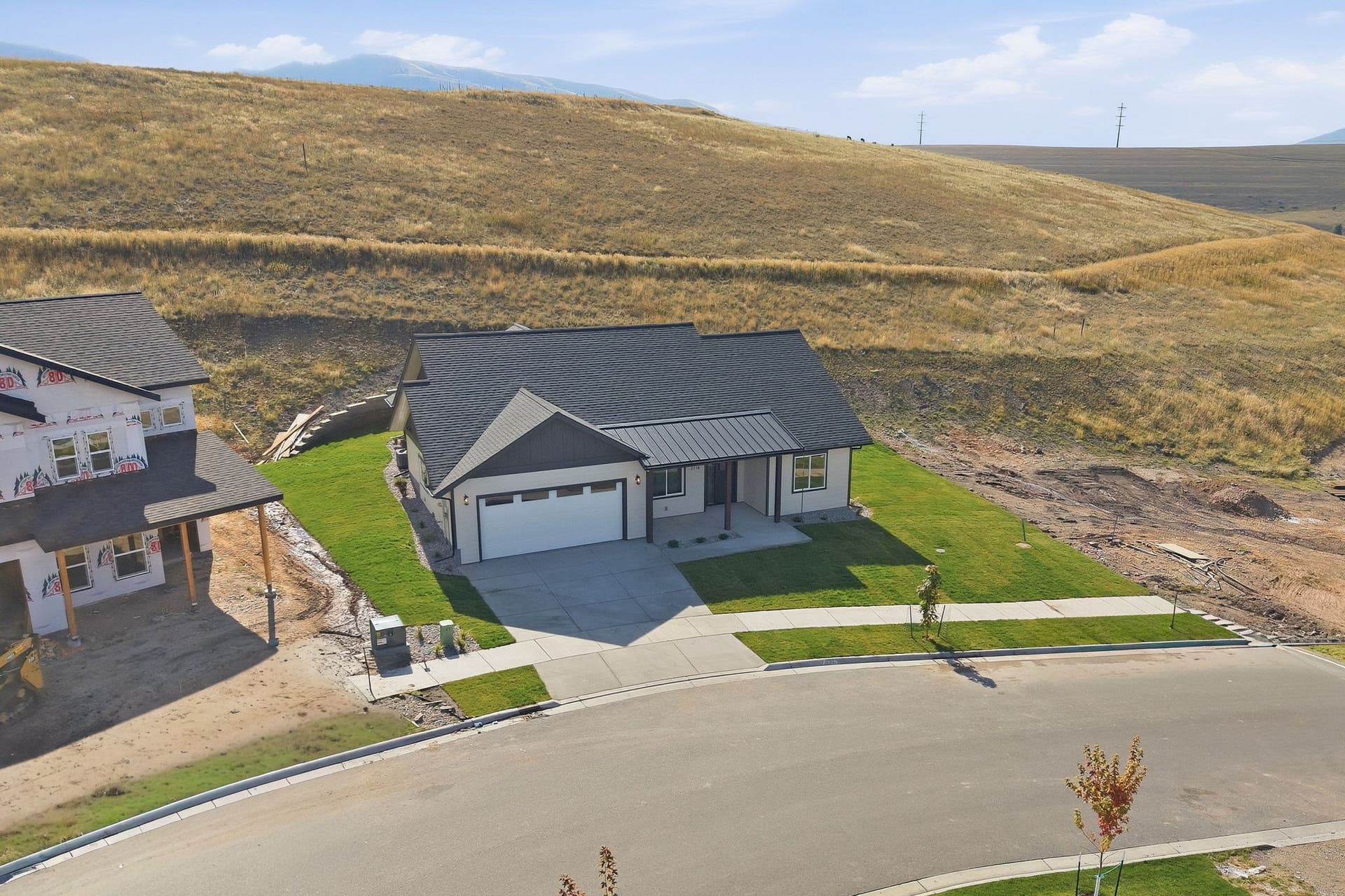 Contemporary single-story residence featuring a two-car garage, dark shingle roof, and a concrete driveway