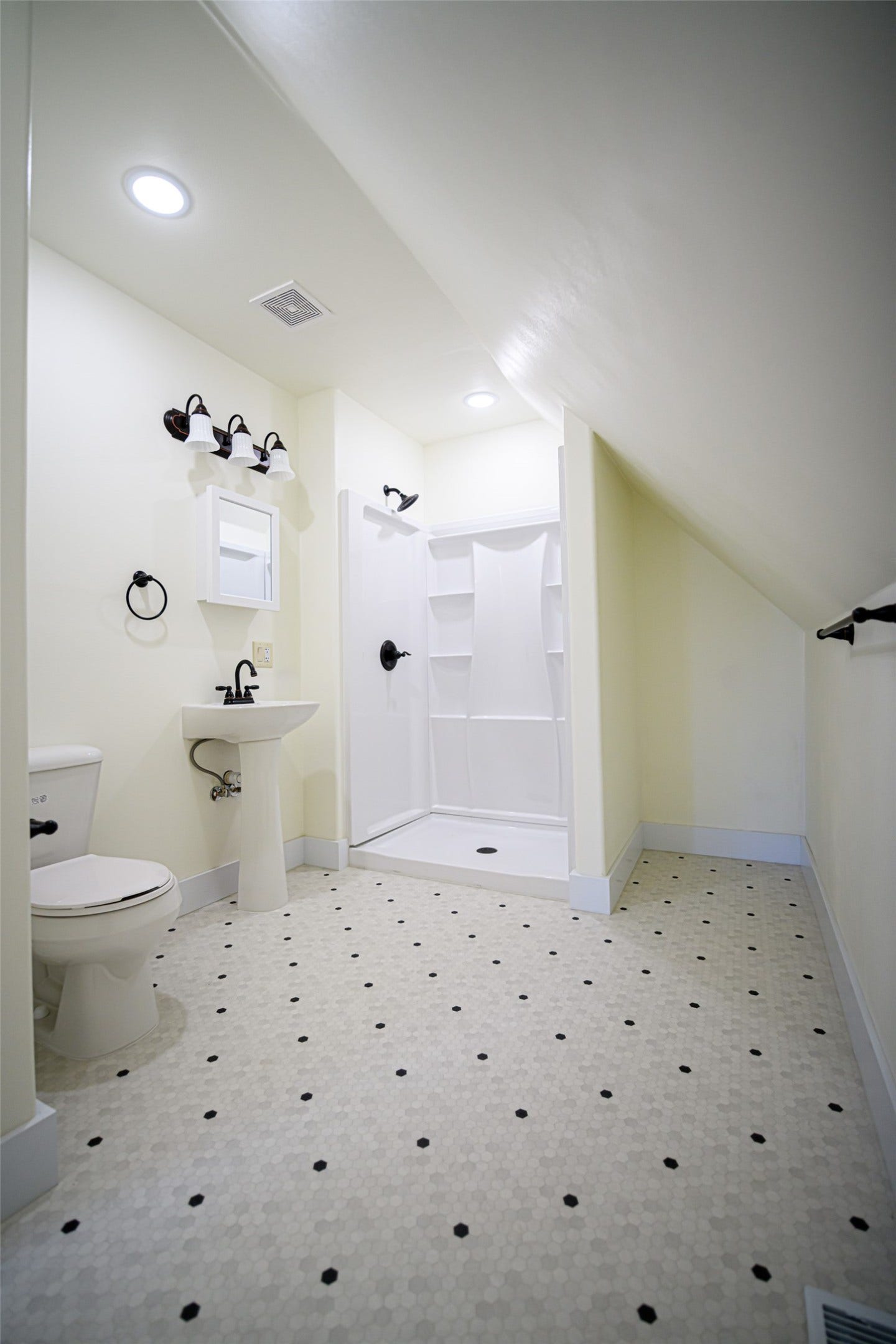705 W Park Street, Butte, MT 59701 Pedestal sink, wall-mounted vanity light fixture, and walk-in shower with dark bronze fixtures
