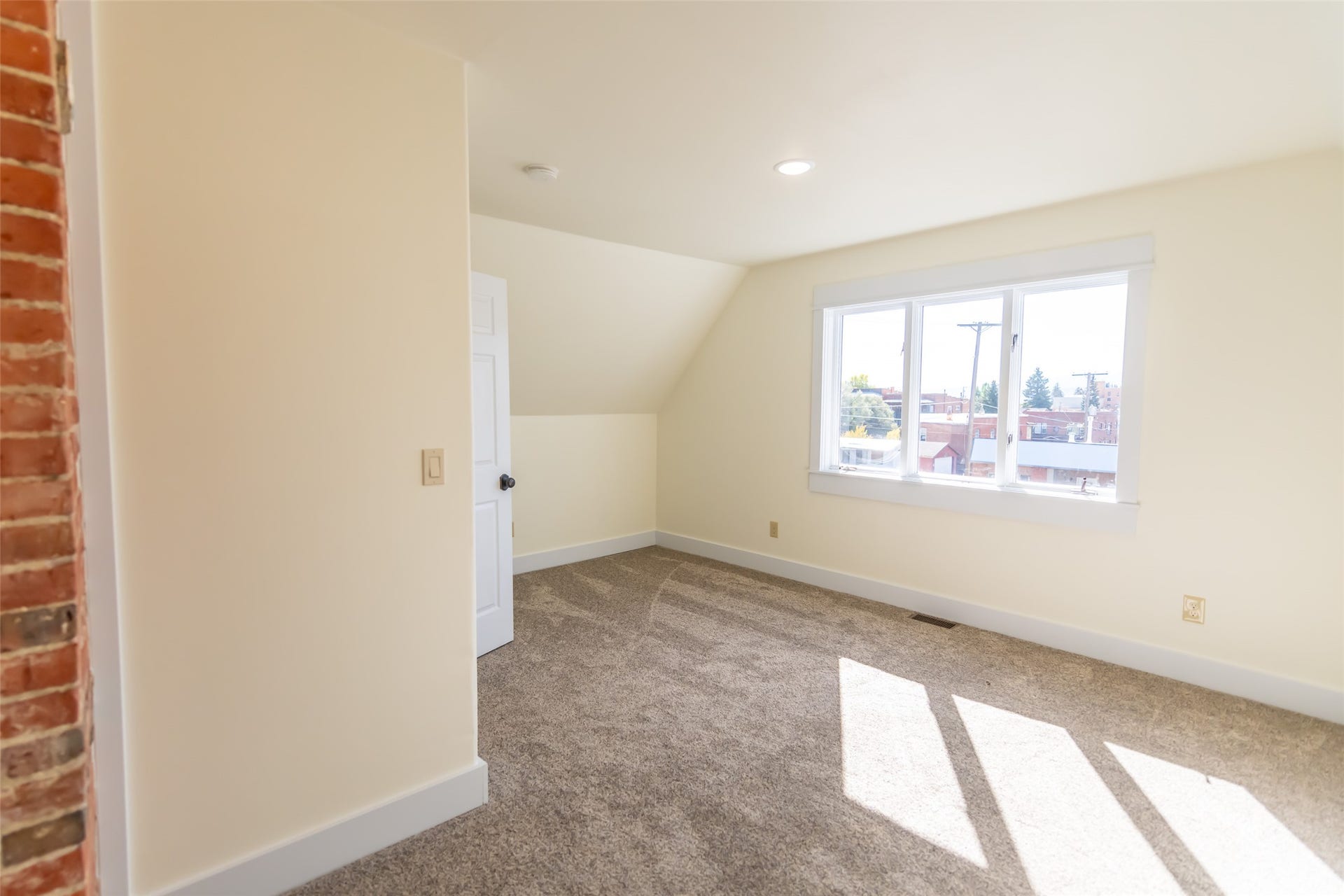 705 W Park Street, Butte, MT 59701 Sloped ceiling room featuring a large multi-pane window, recessed lighting, and carpet flooring