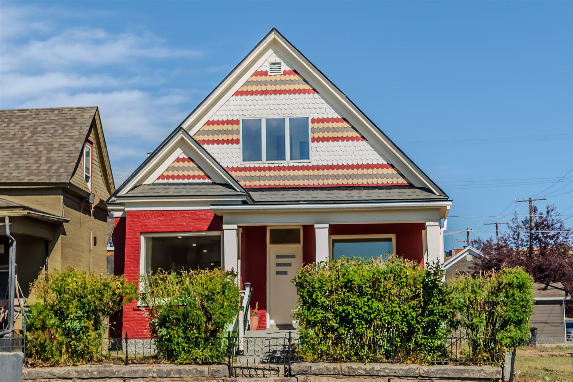 705 W Park Street, Butte, MT 59701 Red brick exterior with white trim, multi-colored shingle siding, covered front porch, and mature front landscaping