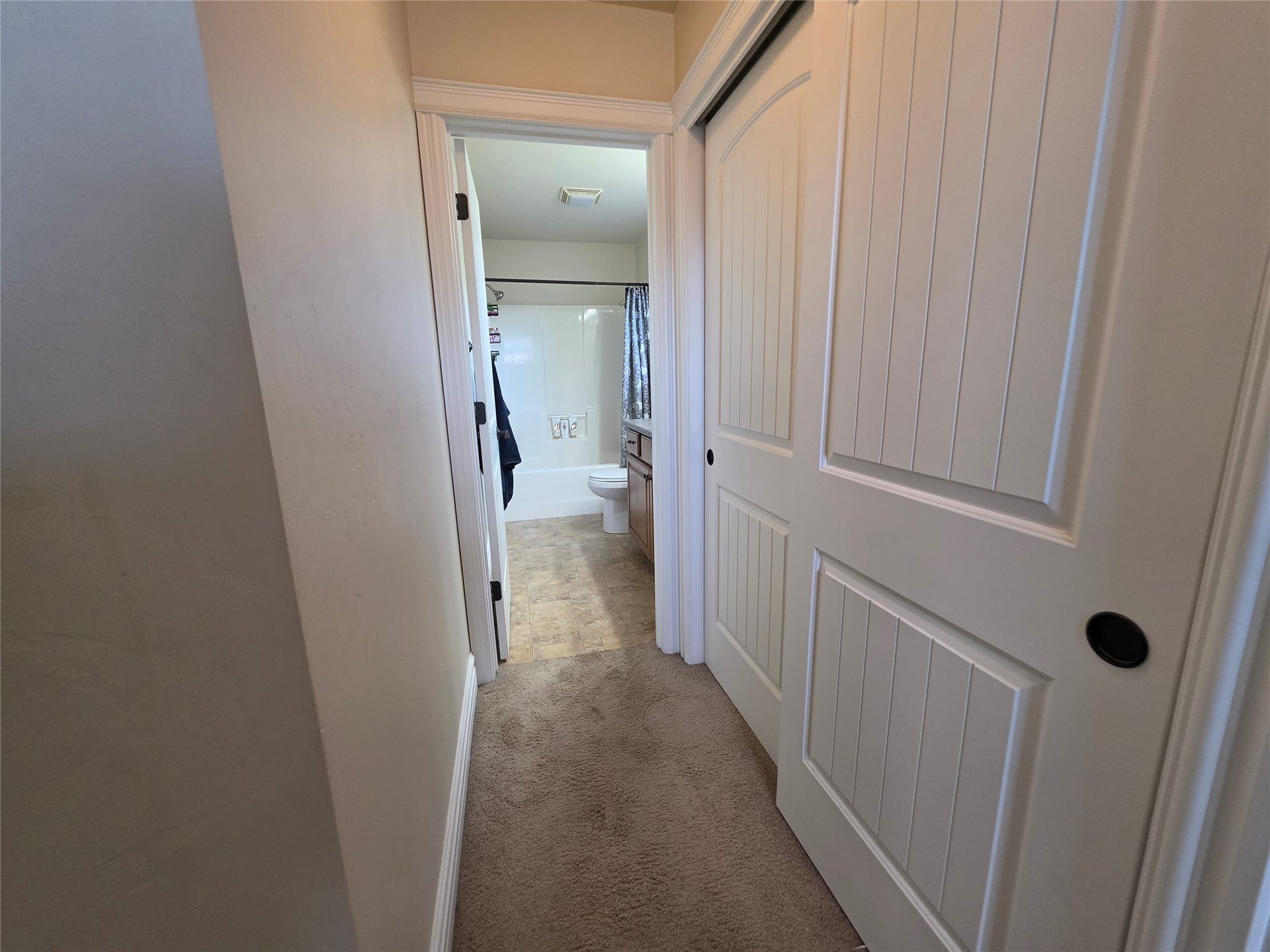 585 Wildflower Circle, Hamilton, MT 59840 Hallway featuring carpet flooring and white paneled bi-fold doors with dark hardware