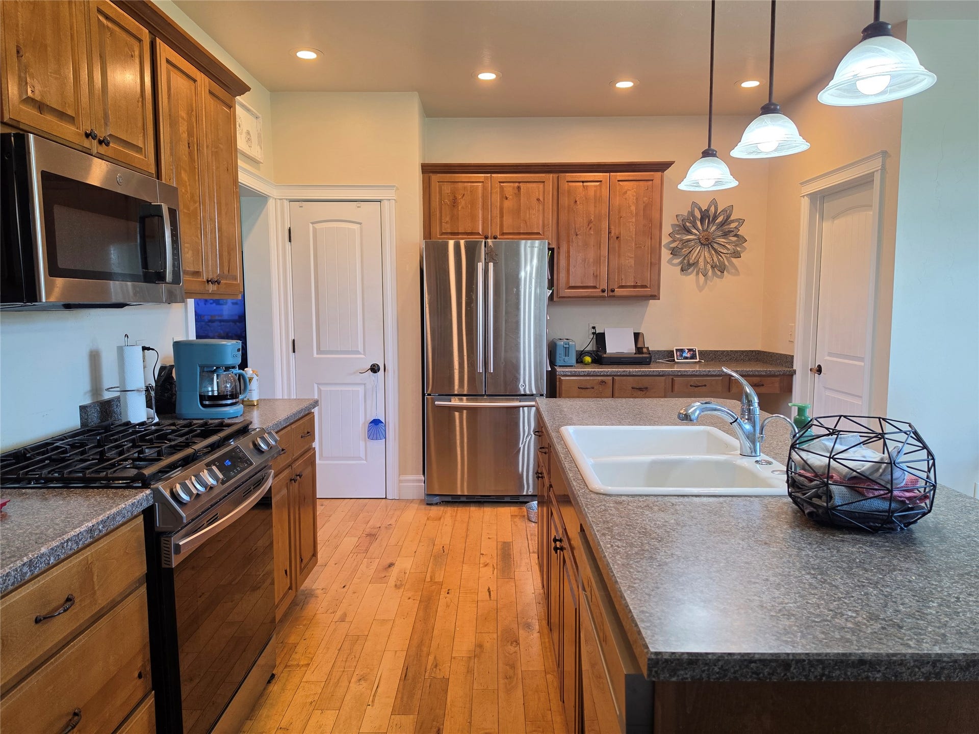585 Wildflower Circle, Hamilton, MT 59840 Kitchen featuring wood-finish cabinetry, stainless steel appliances, a center island with an integrated sink, and pendant lighting