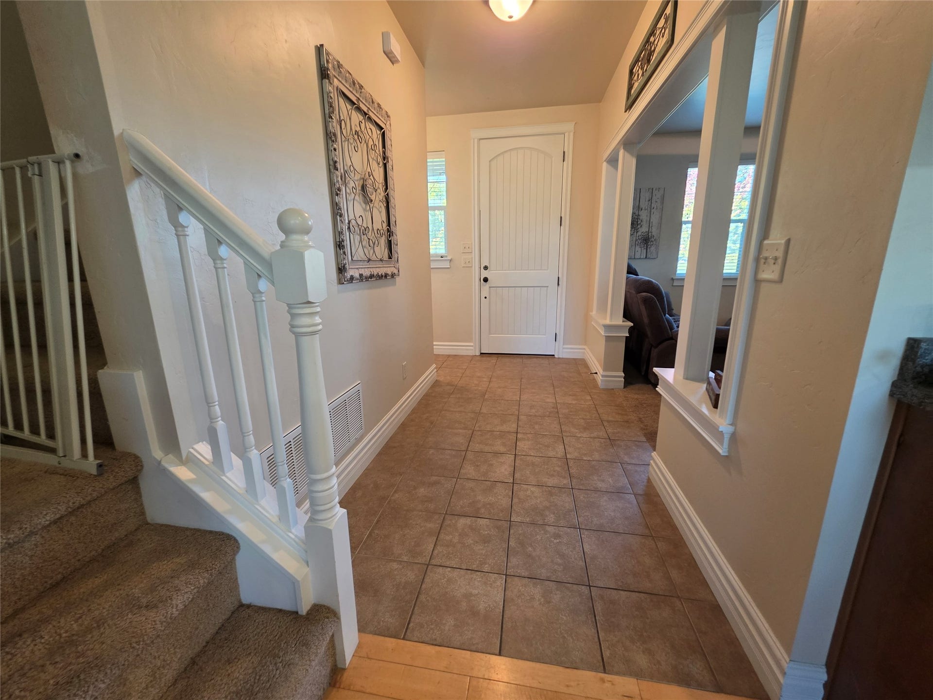 585 Wildflower Circle, Hamilton, MT 59840 Front entry featuring neutral tile flooring, a white paneled door, and a staircase with white balusters